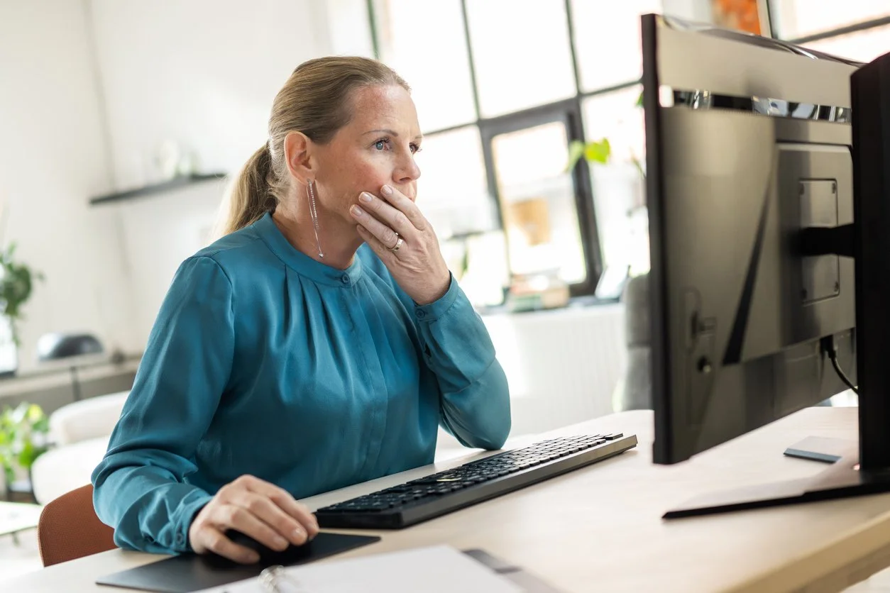 blonde woman at desk looking stressed