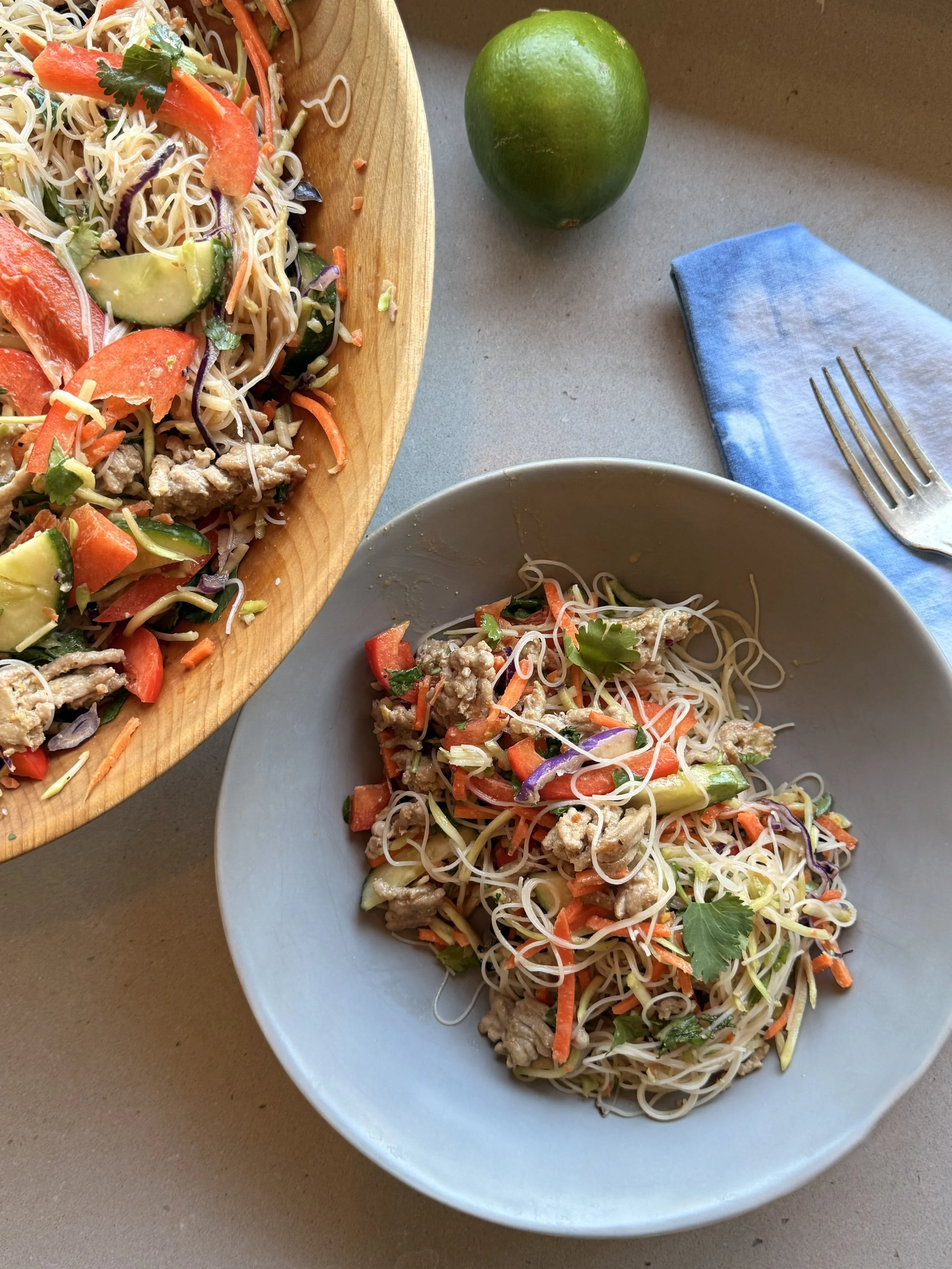 Rice noodles, vegetables and a peanut dressing in a large bowl
