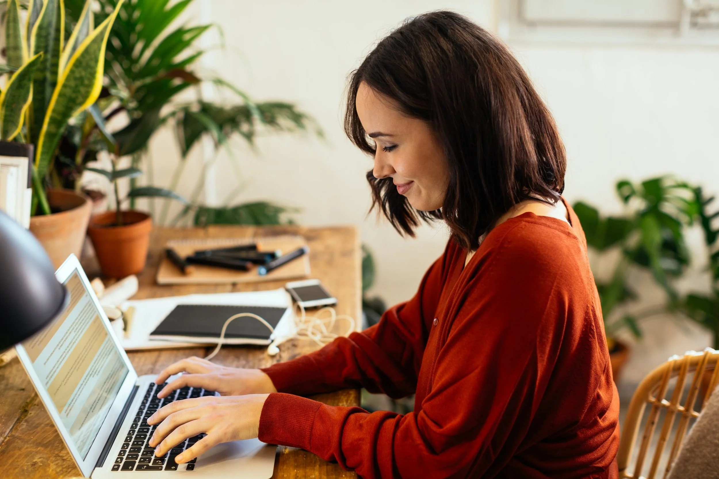 Seitenansicht einer Frau, die auf einem Laptop tippt