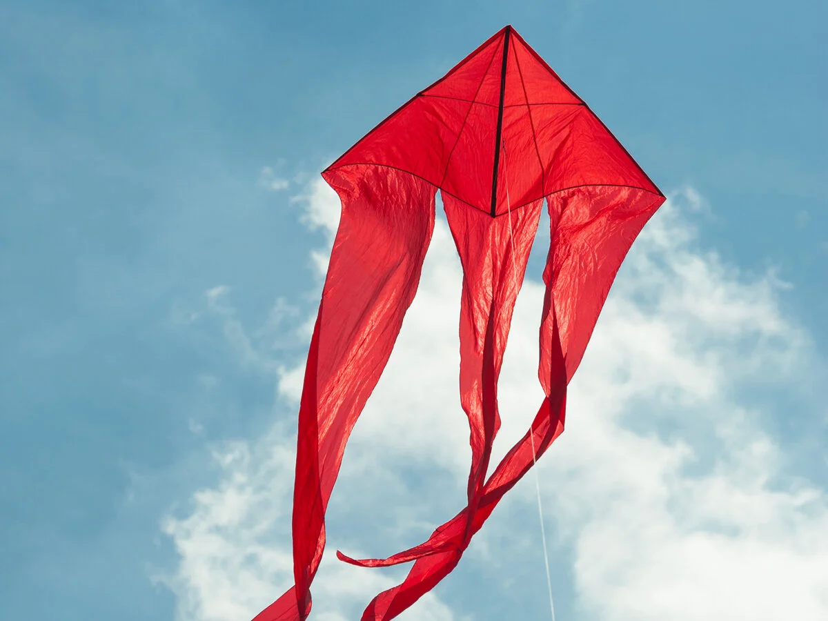 Cometa roja flotando en un cielo soleado