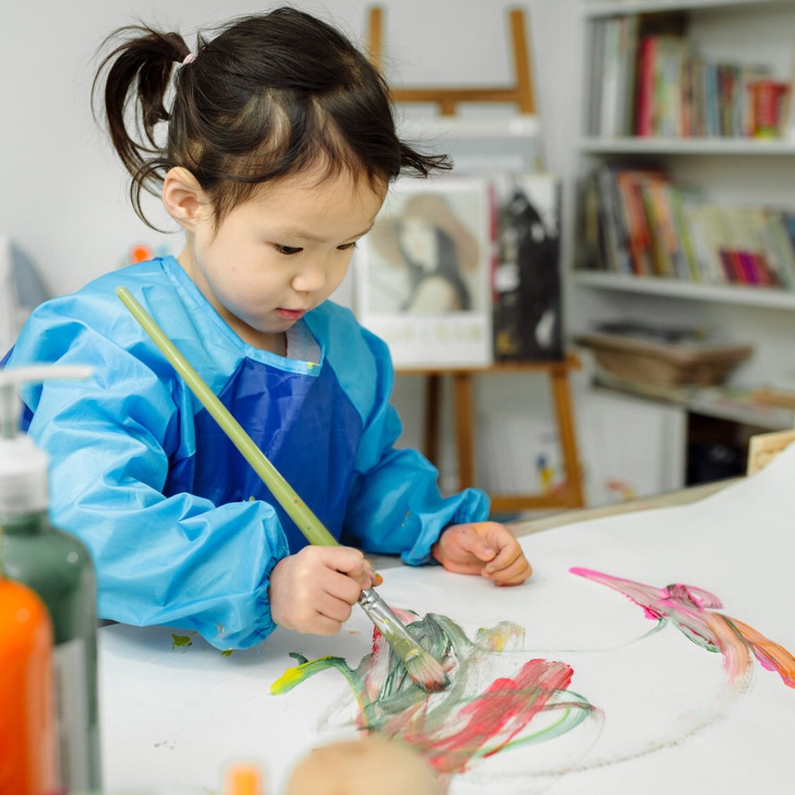 Une jeune enfant qui peint à l’aquarelle
