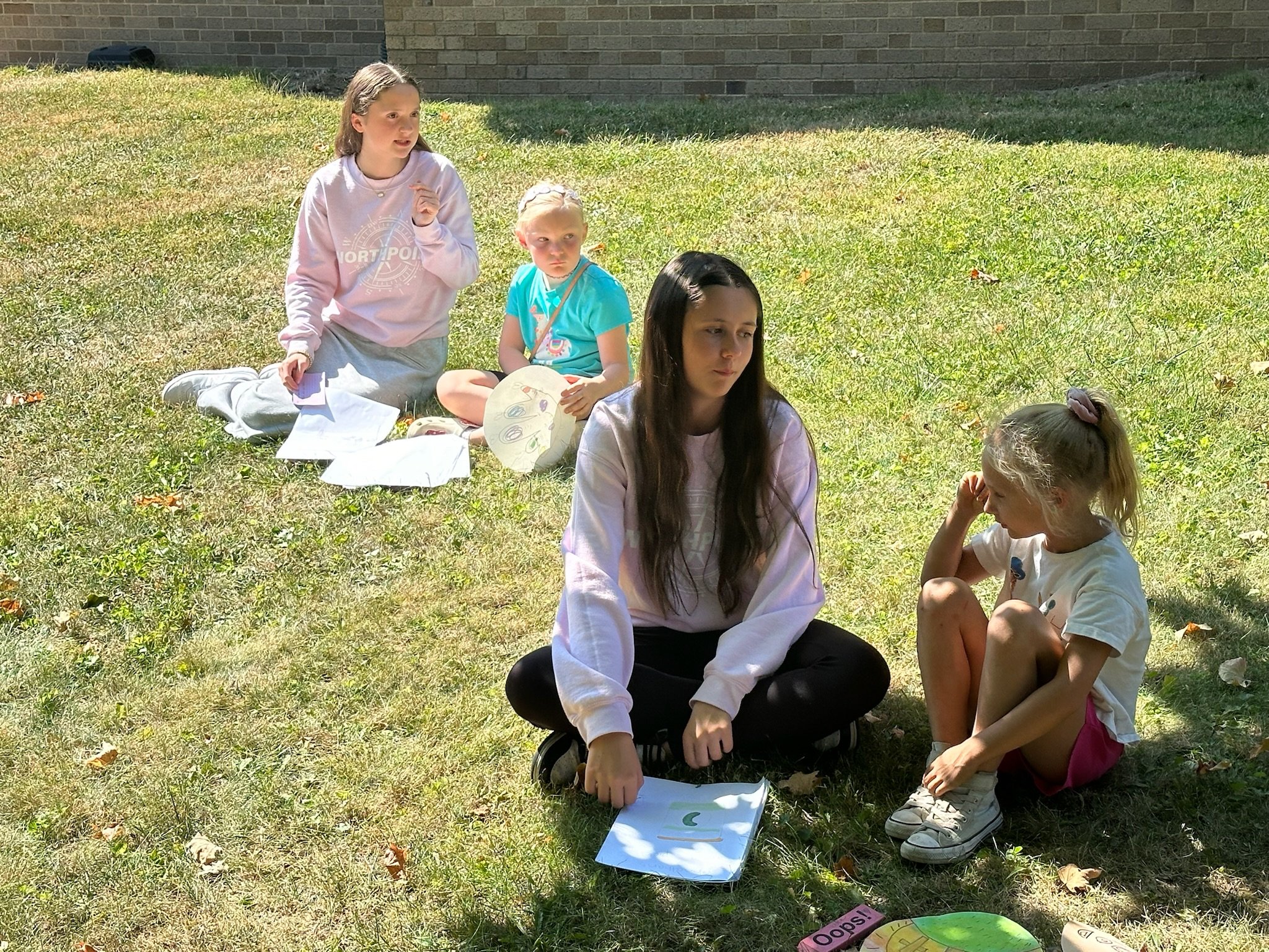 Group of eight people, including five boys and three men, standing on a basketball court inside a gymnasium, some holding basketballs, smiling for the photo.