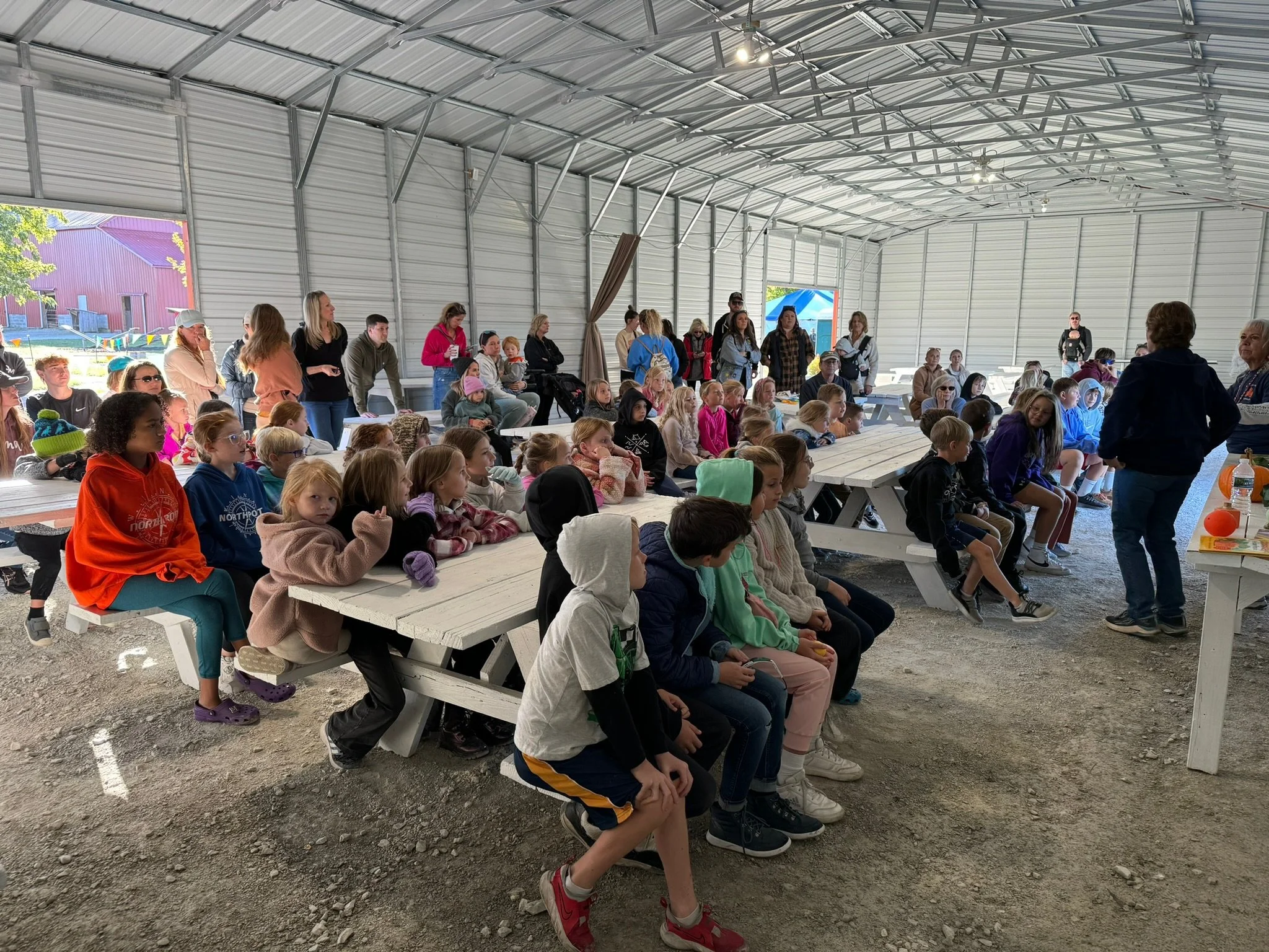 Children enjoying a meal at a round table in a cafeteria.