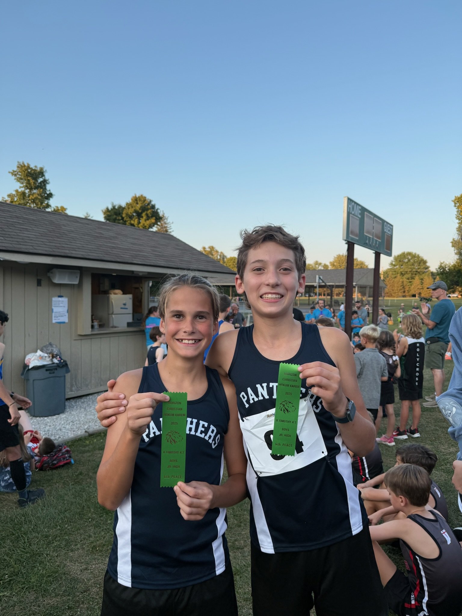 Children playing with race car track toys in a room with brick walls and large window.