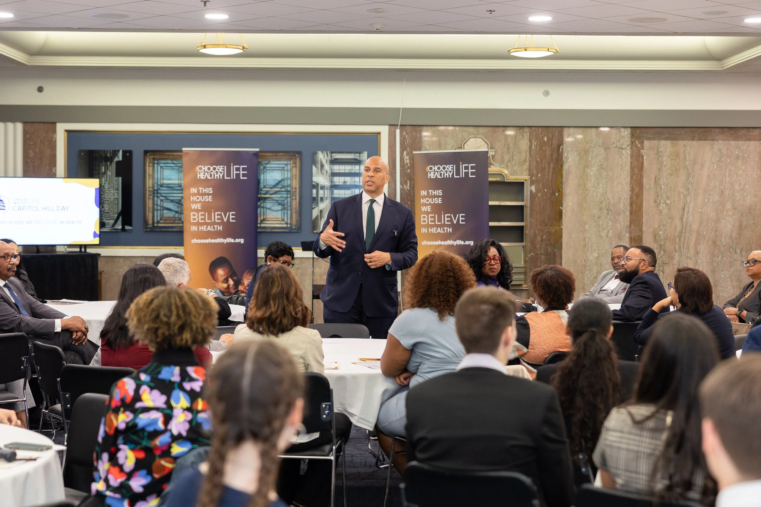 Sen. Cory Booker (NJ) steps into the center of the room to deliver remarks