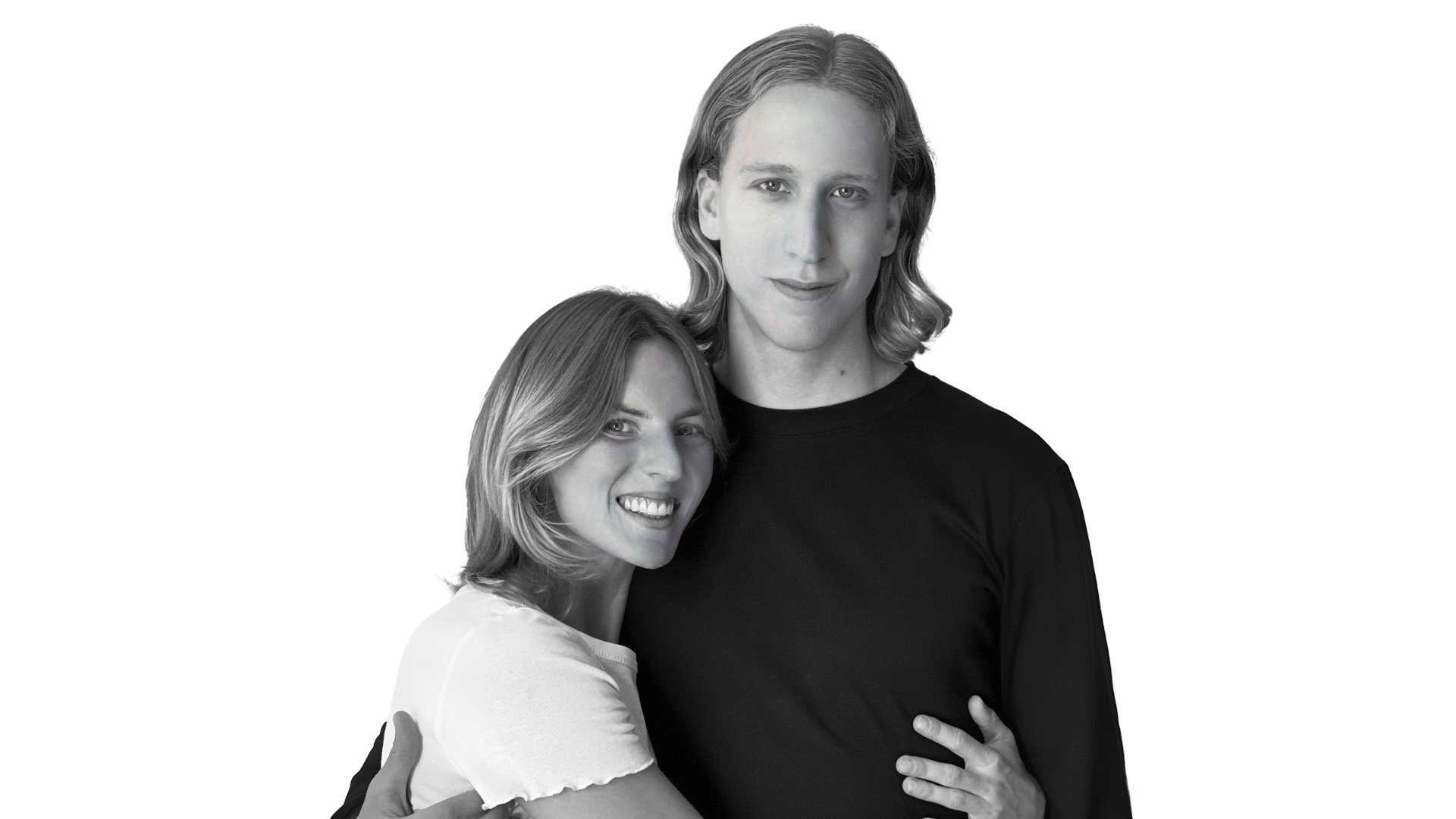 A black-and-white photo of a young man and woman smiling and embracing each other, with the woman slightly leaning into the man.