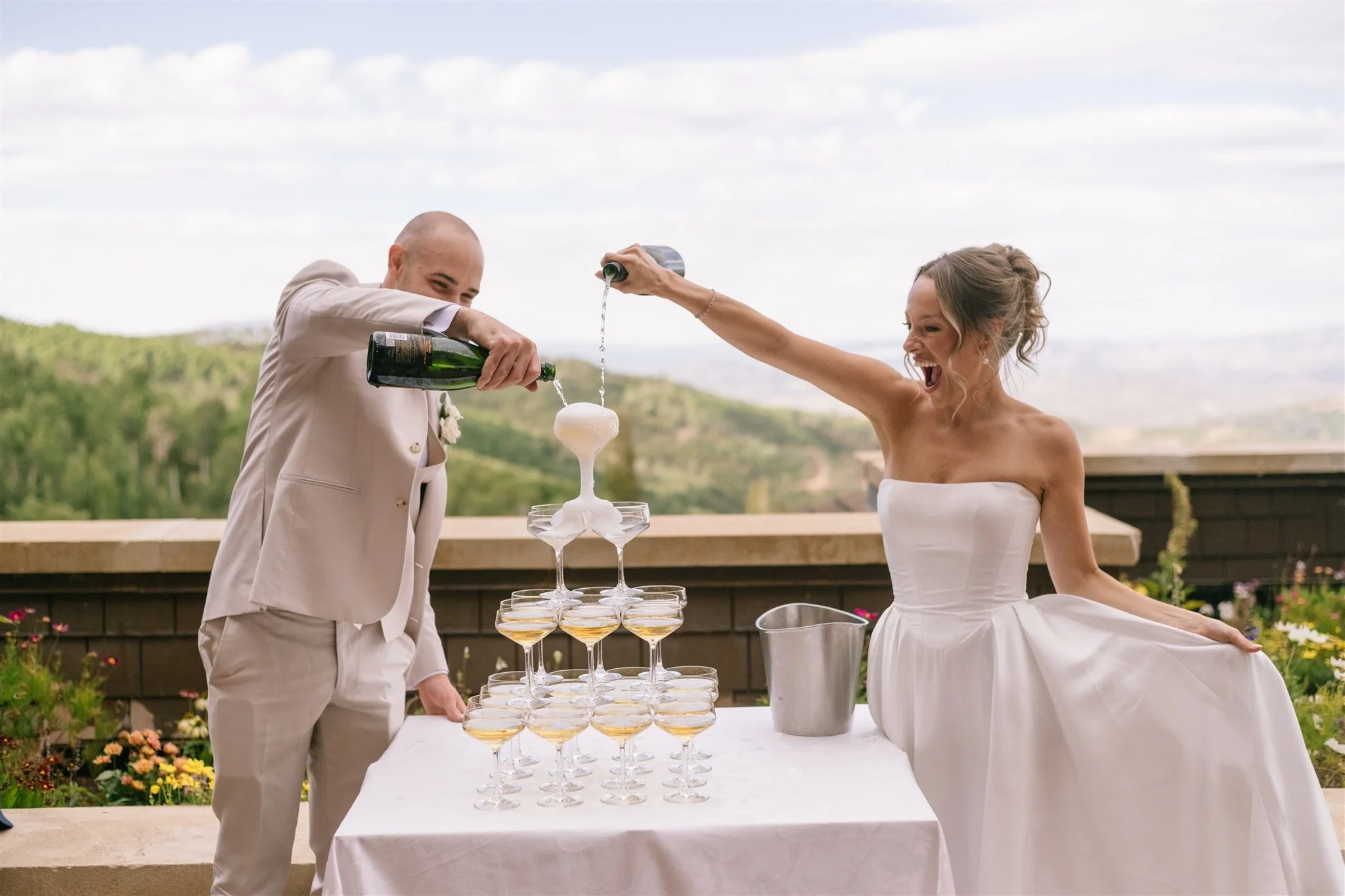 unposed-couple-pouring-champagne-tower-mountain-view.jpg