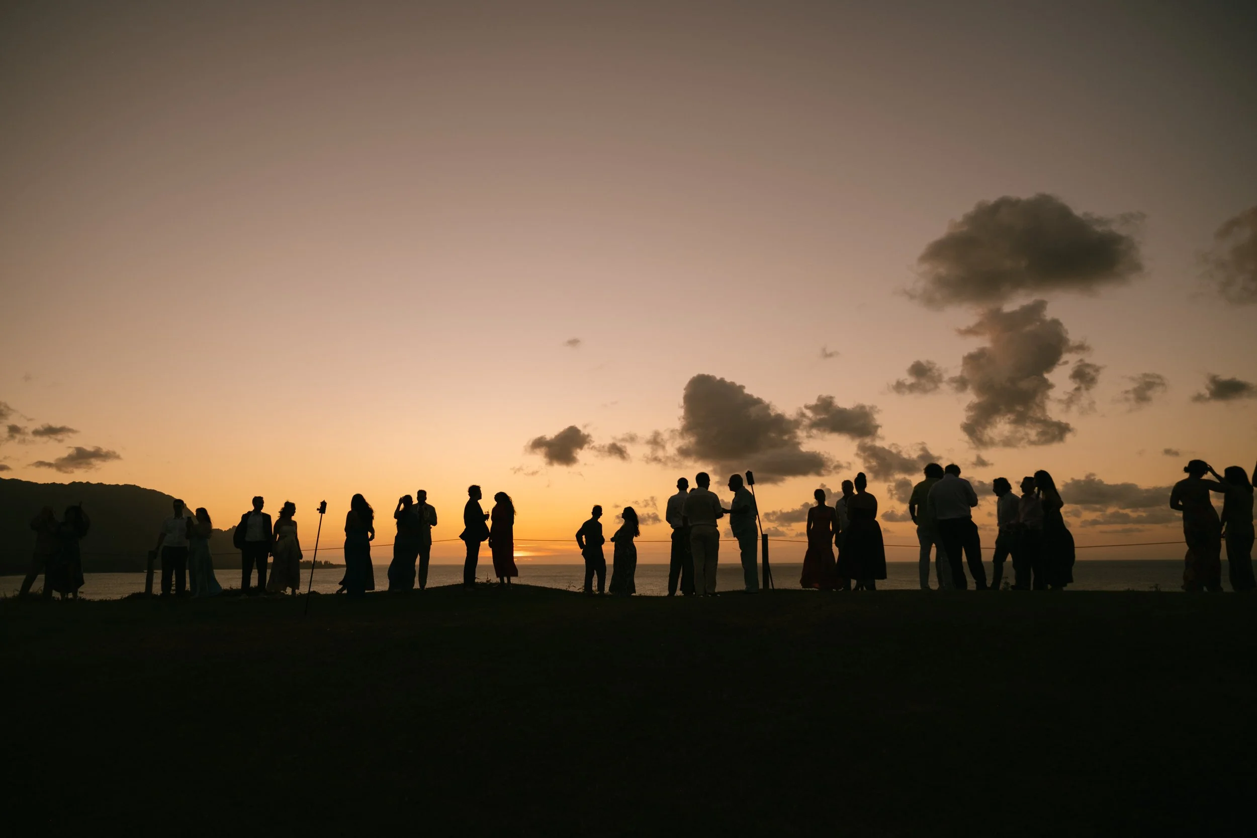 documentary-style-guests-silhouetted-at-sunset-cocktail-hour.jpg