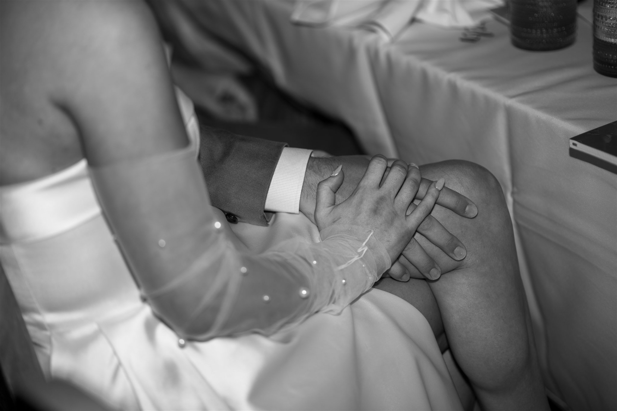holding-hands-at-reception-table-black-and-white.jpg