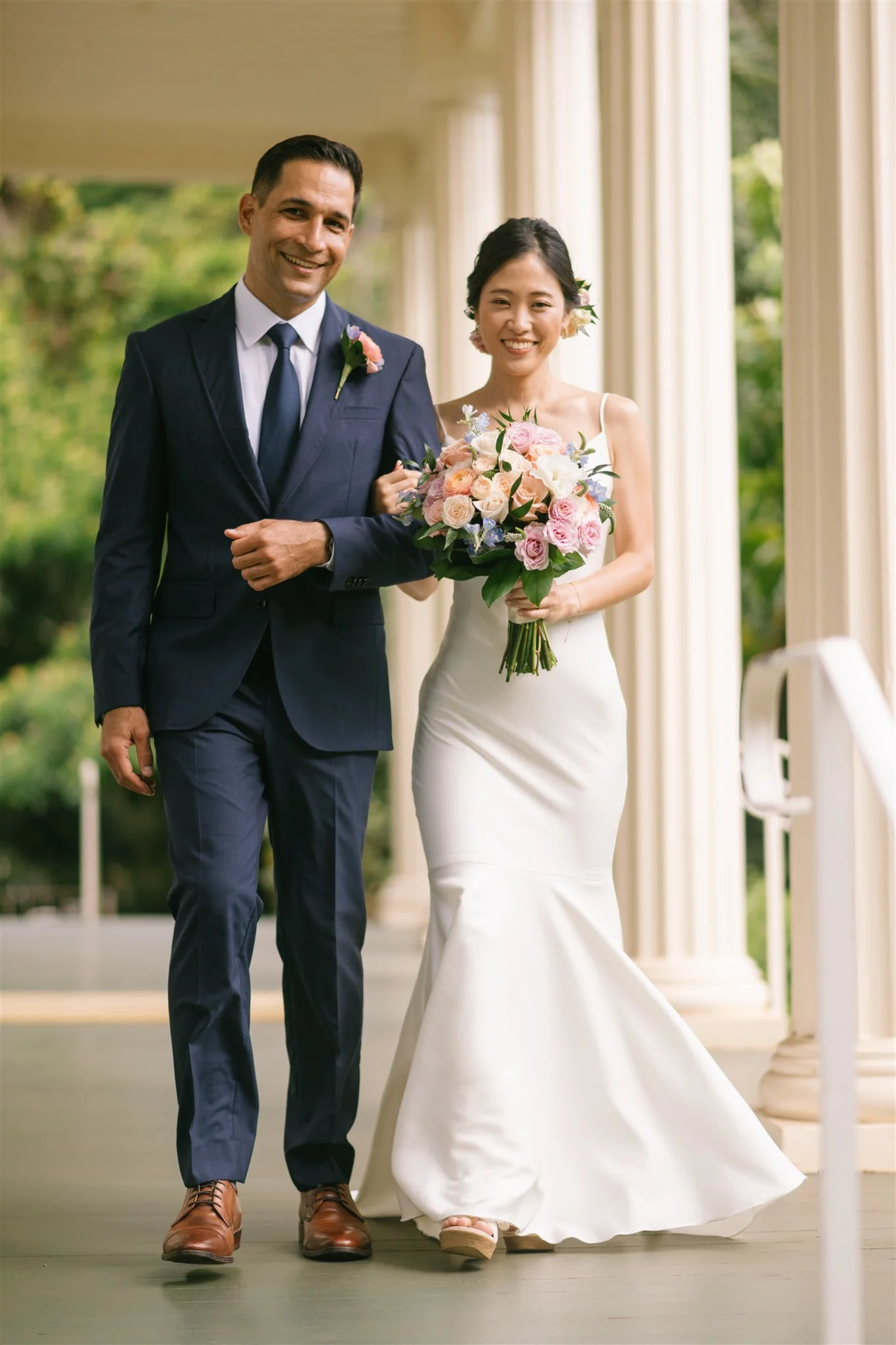 bride-and-groom-walking-colonnade.jpg