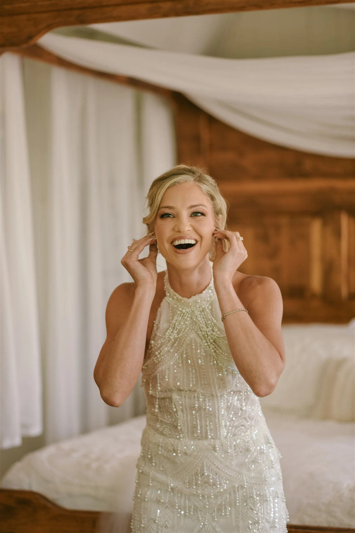 candid-bride-getting-ready-earrings-beaded-gown.jpg