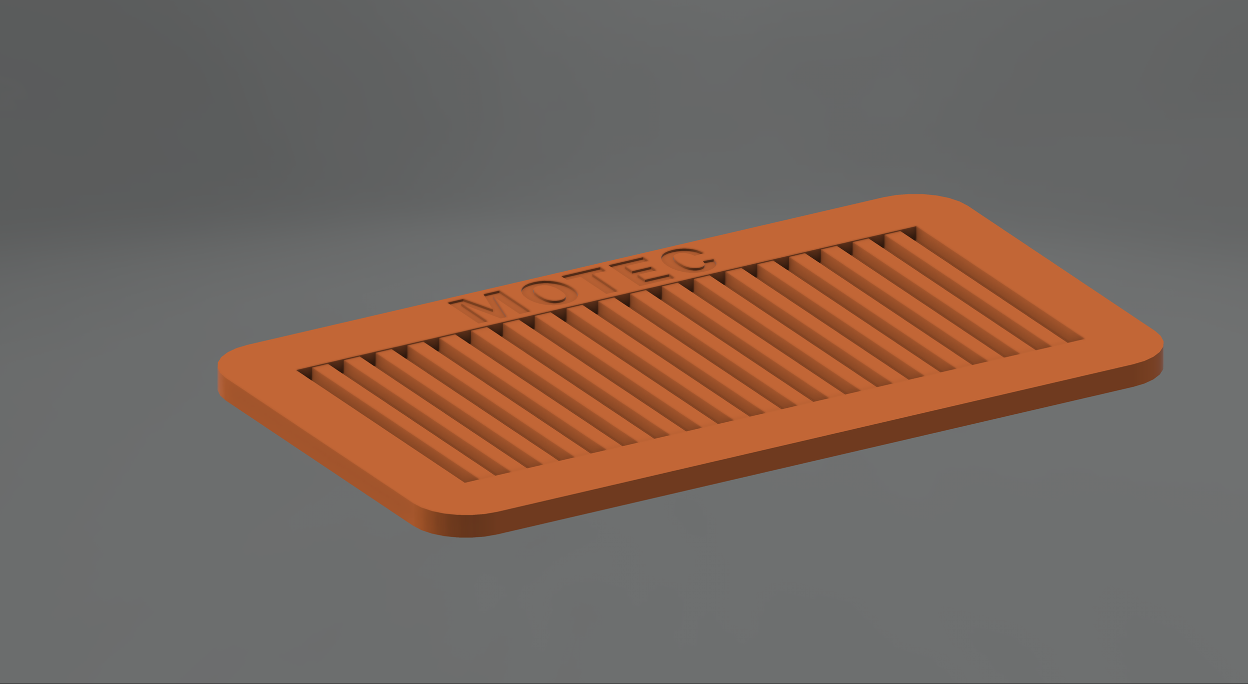 Orange heel rest with the word 'MOTEC' engraved on it, placed on a grey surface.