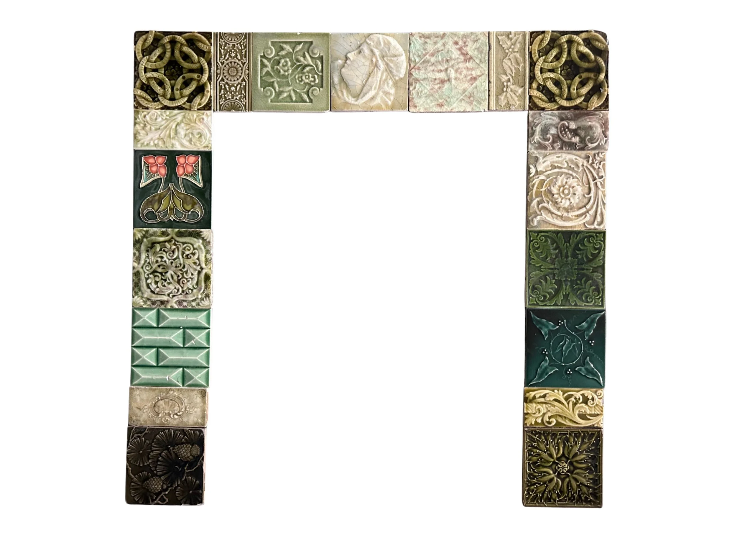 Antique Victorian decorative tile fireplace surround featuring intricate floral patterns, rich green glazes, and an eclectic mix of historic tiles.