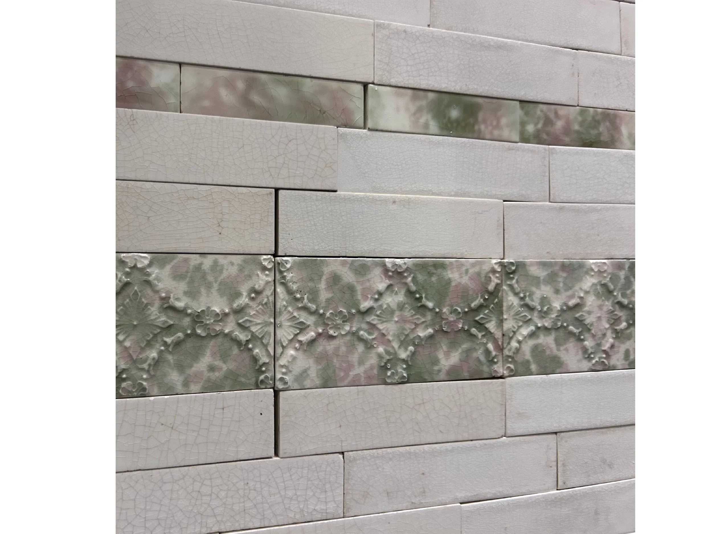 Antique Victorian fireplace surround and hearth featuring pink, green and white mottled tiles, decorative floral inserts, checkerboard design