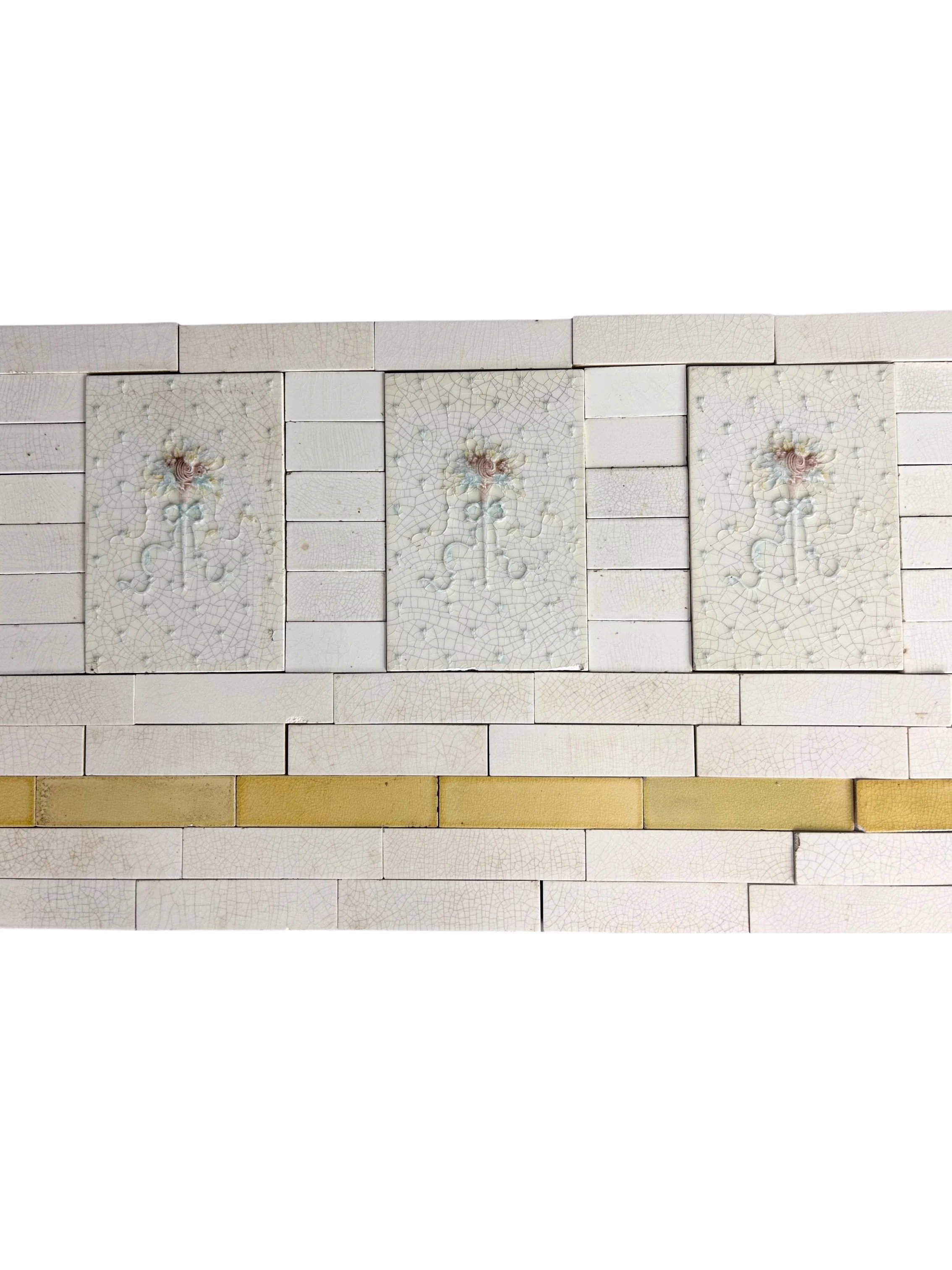 Antique Victorian fireplace surround and hearth featuring delicate floral tiles, pale crackle glazes, and soft blue, pink, yellow, and cream details.
