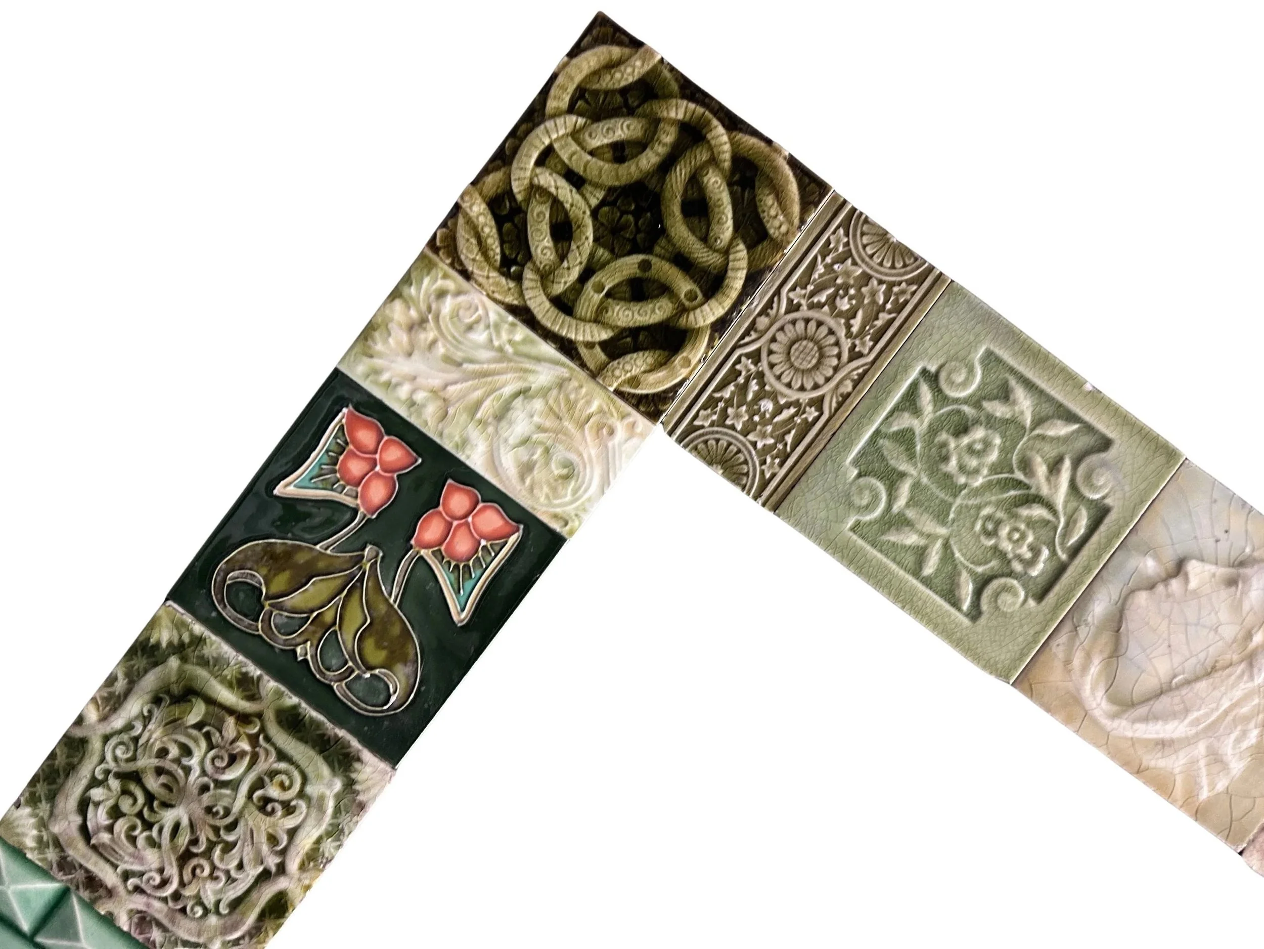 Antique Victorian decorative tile fireplace surround featuring intricate floral patterns, rich green glazes, and an eclectic mix of historic tiles.