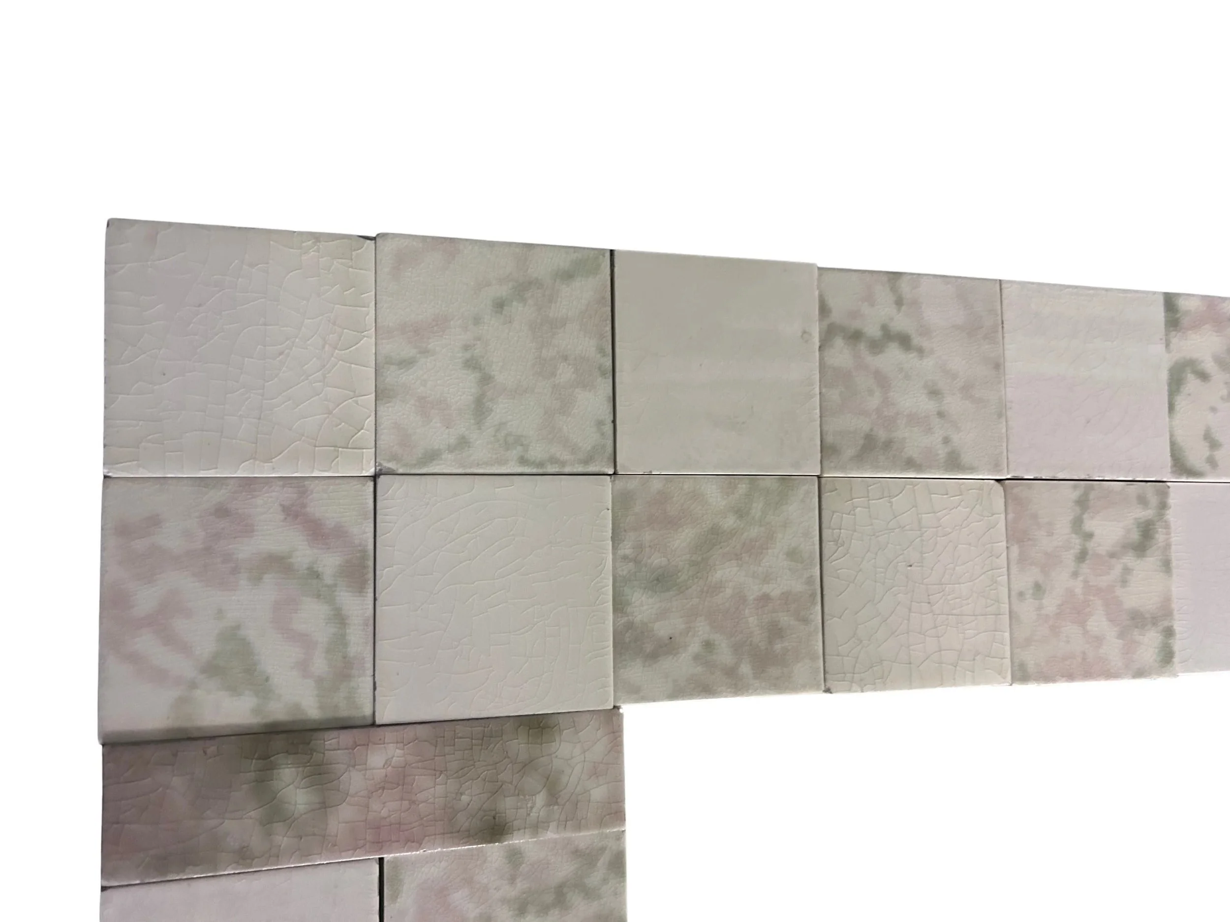 Antique Victorian fireplace surround and hearth featuring pink, green and white mottled tiles, decorative floral inserts, checkerboard design