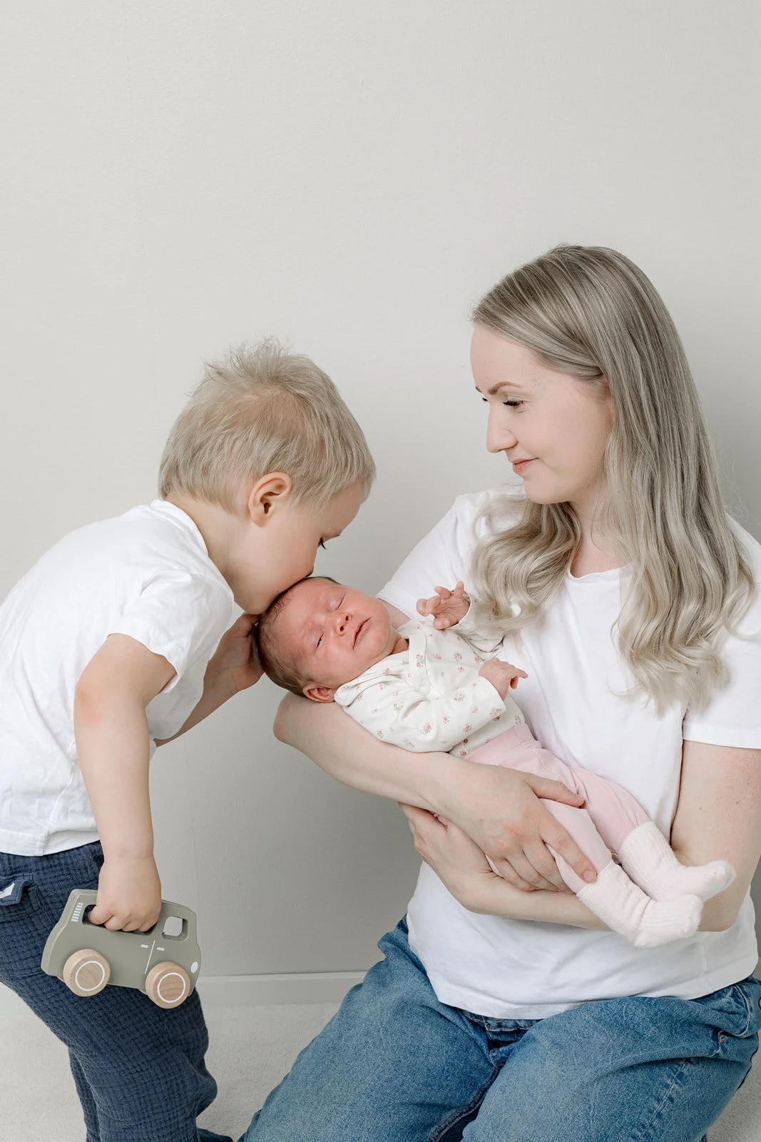 Vauvakuvaus Studio Susannamariassa. Pieni poika suukottaa vastasyntynyttä veljeään joka on äidin sylissä.