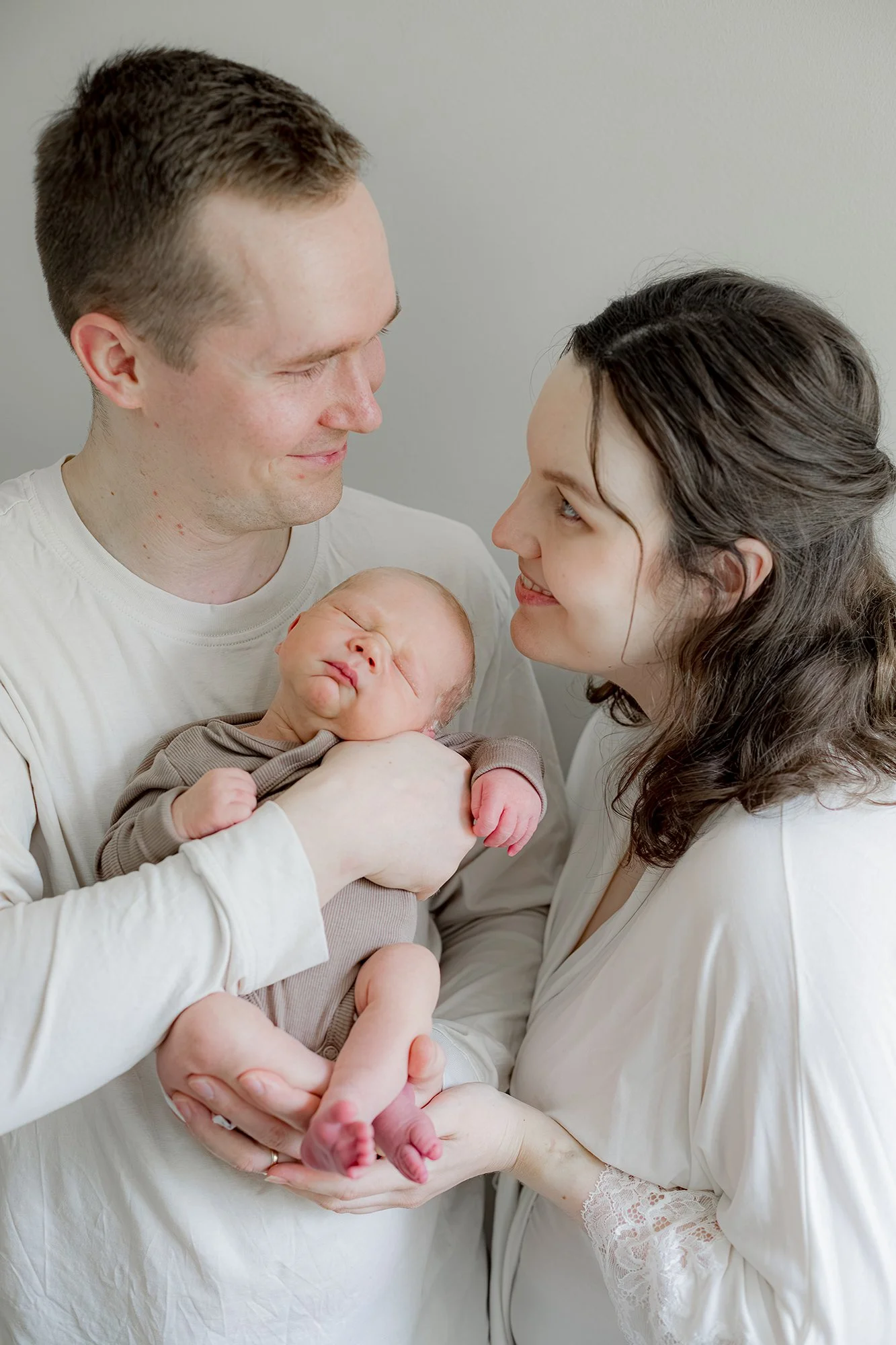 Äiti ja isä katsovat hellästi toisiinsa, isä pitää sylissä heidän vastasyntynyttä poikaa