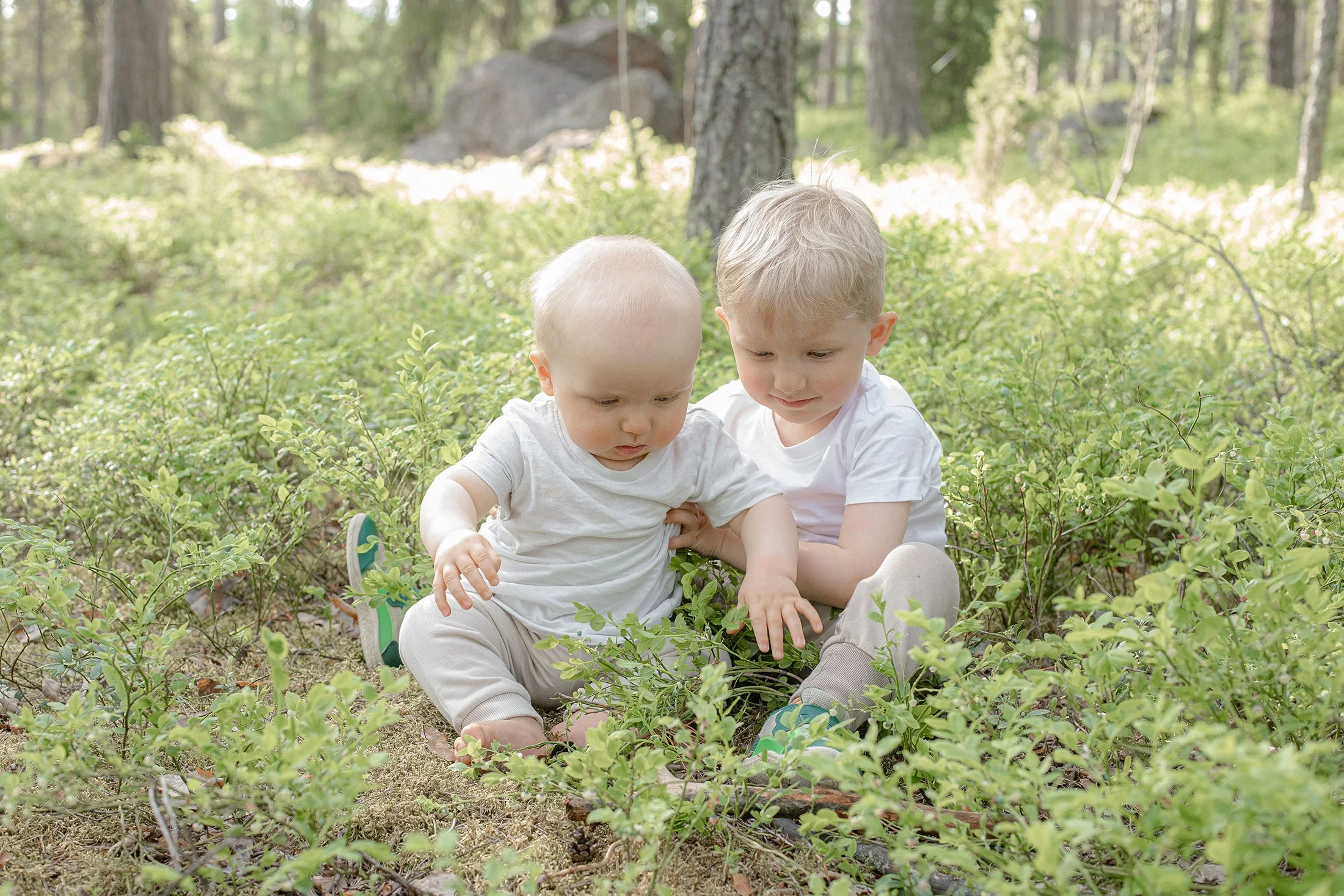 Äiti ja tytär käsi kädessä, molemmilla yllä vaaleat mekot