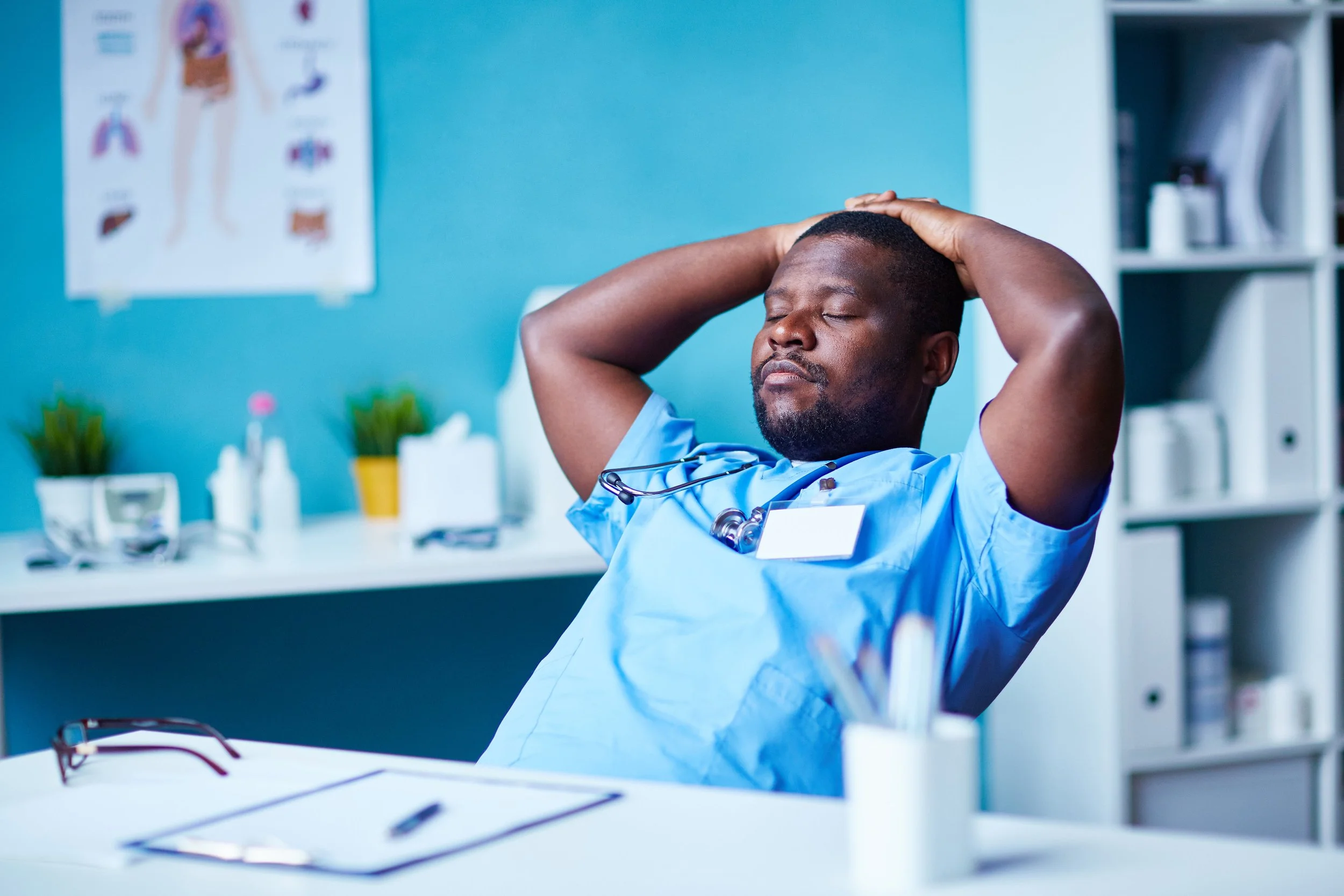 Healthcare worker in scrubs closing eyes and trying to relax on a break