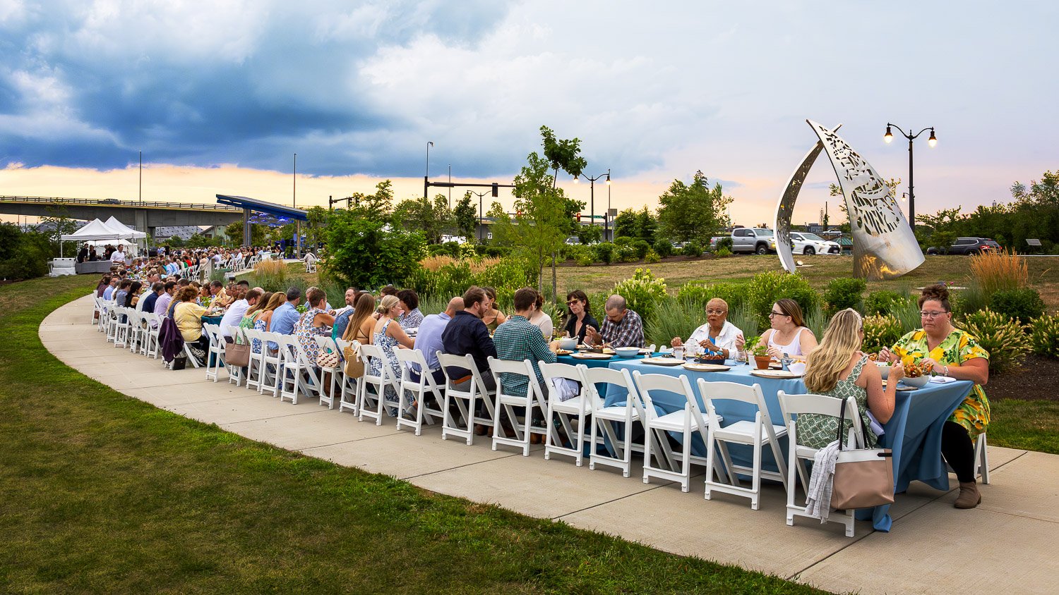 Panoramic view of long dining tables along the river at Street.life 2025 in Portsmouth NH