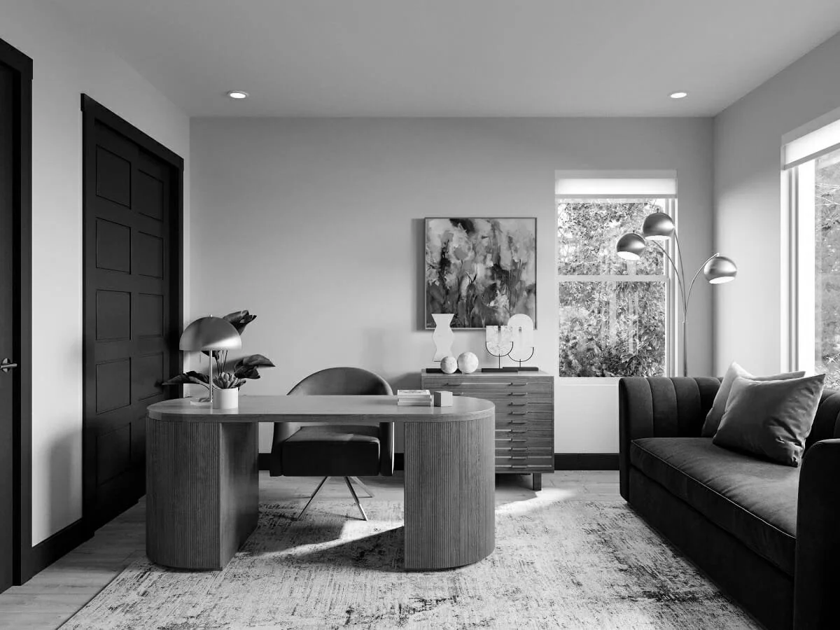 A modern living room and office space in black and white with a desk, chair, sofa, painting, and decorative objects.