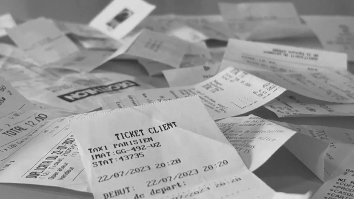 A messy pile of receipts and tickets, including a taxi ticket for Paris with details like date, time, and start code.