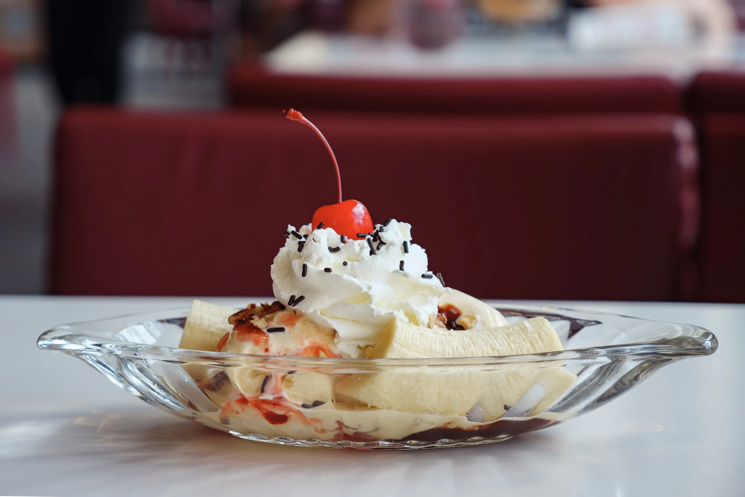 Banana split sundae with sprinkles, whipped cream, and a cherry on top