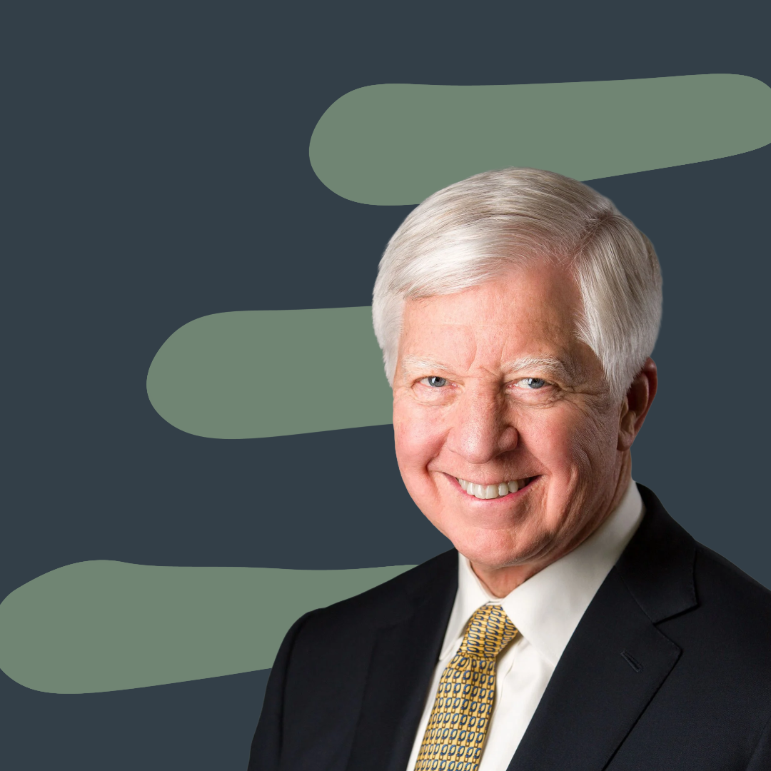 Our first ever guest, Bill George, with white hair in a suit and tie, smiling, with a dark background featuring light green abstract shapes.
