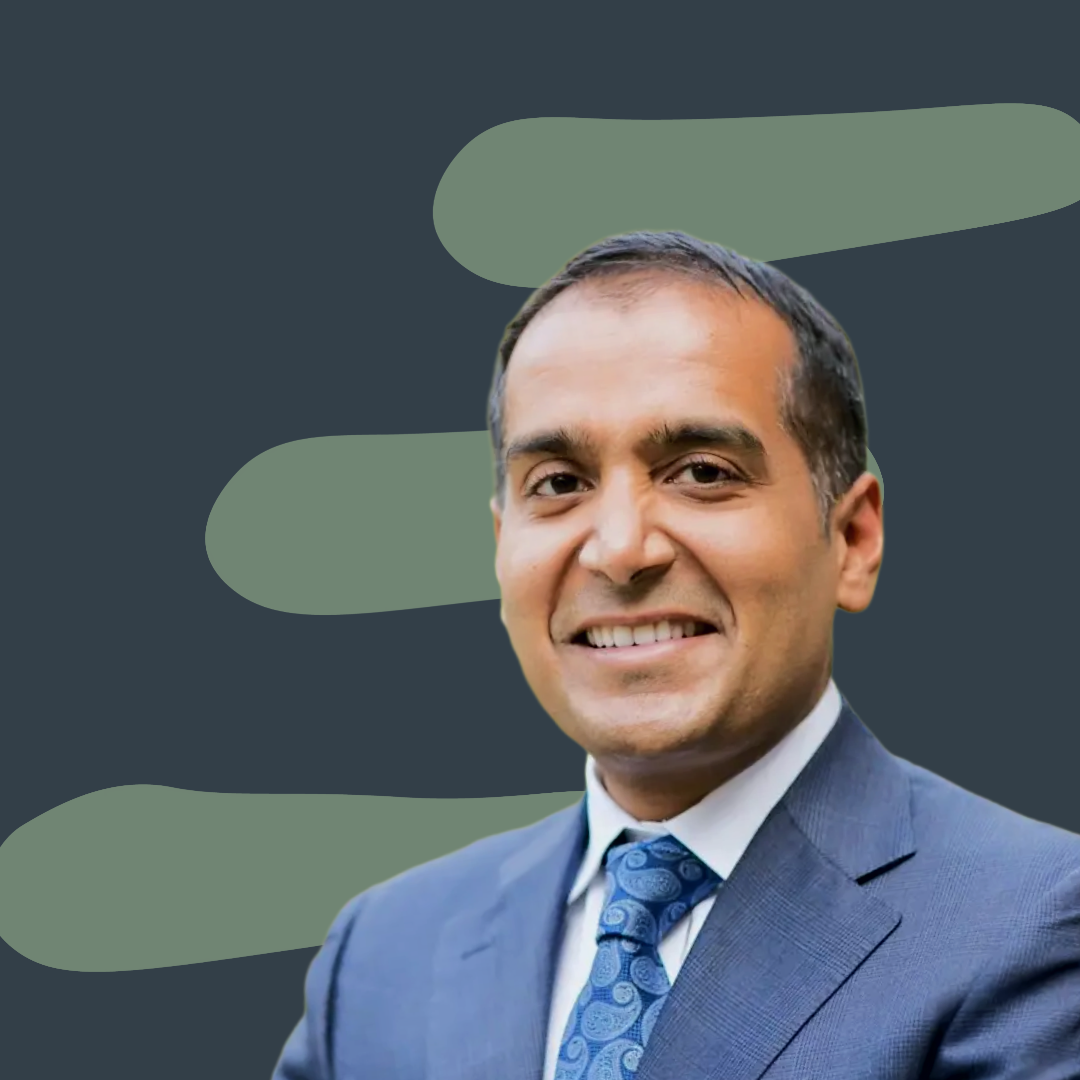 Dr. Sachin Jain, guest on Step Wise season 1, wearing a business suit and tie, smiling, with a graphic background.