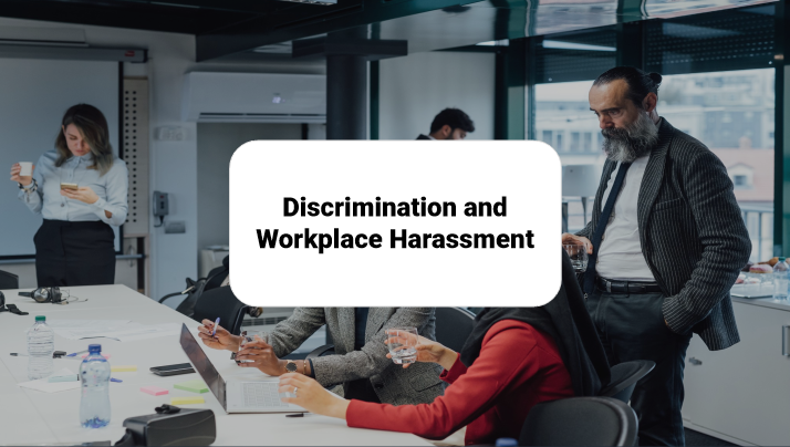 People in a meeting room with a presentation slide titled 'Discrimination and Workplace Harassment' displayed on the screen.