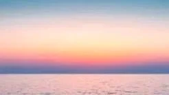 Sunset over a calm ocean with colorful sky and horizon