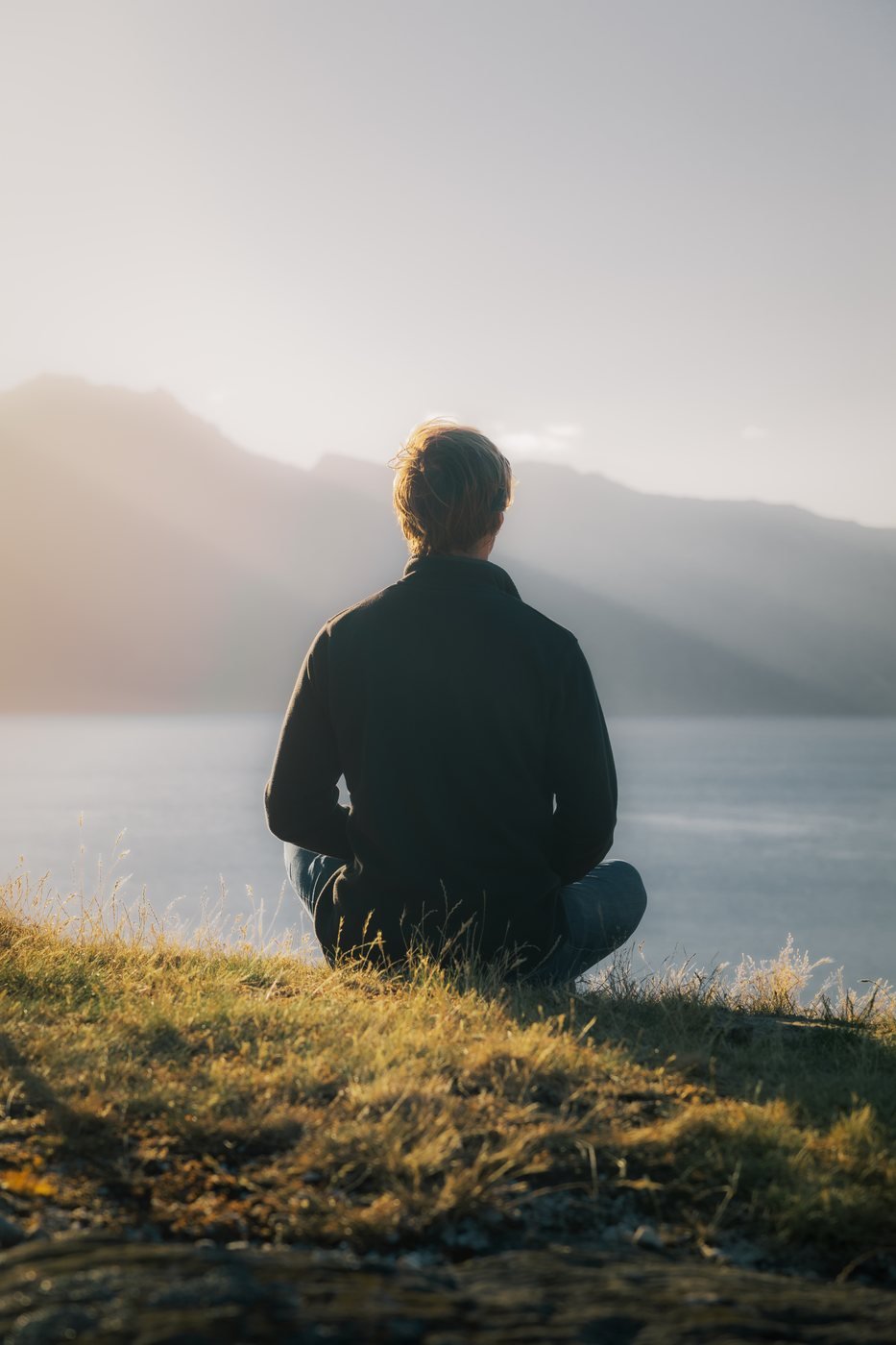 man staring at mountain during difficult life transition
