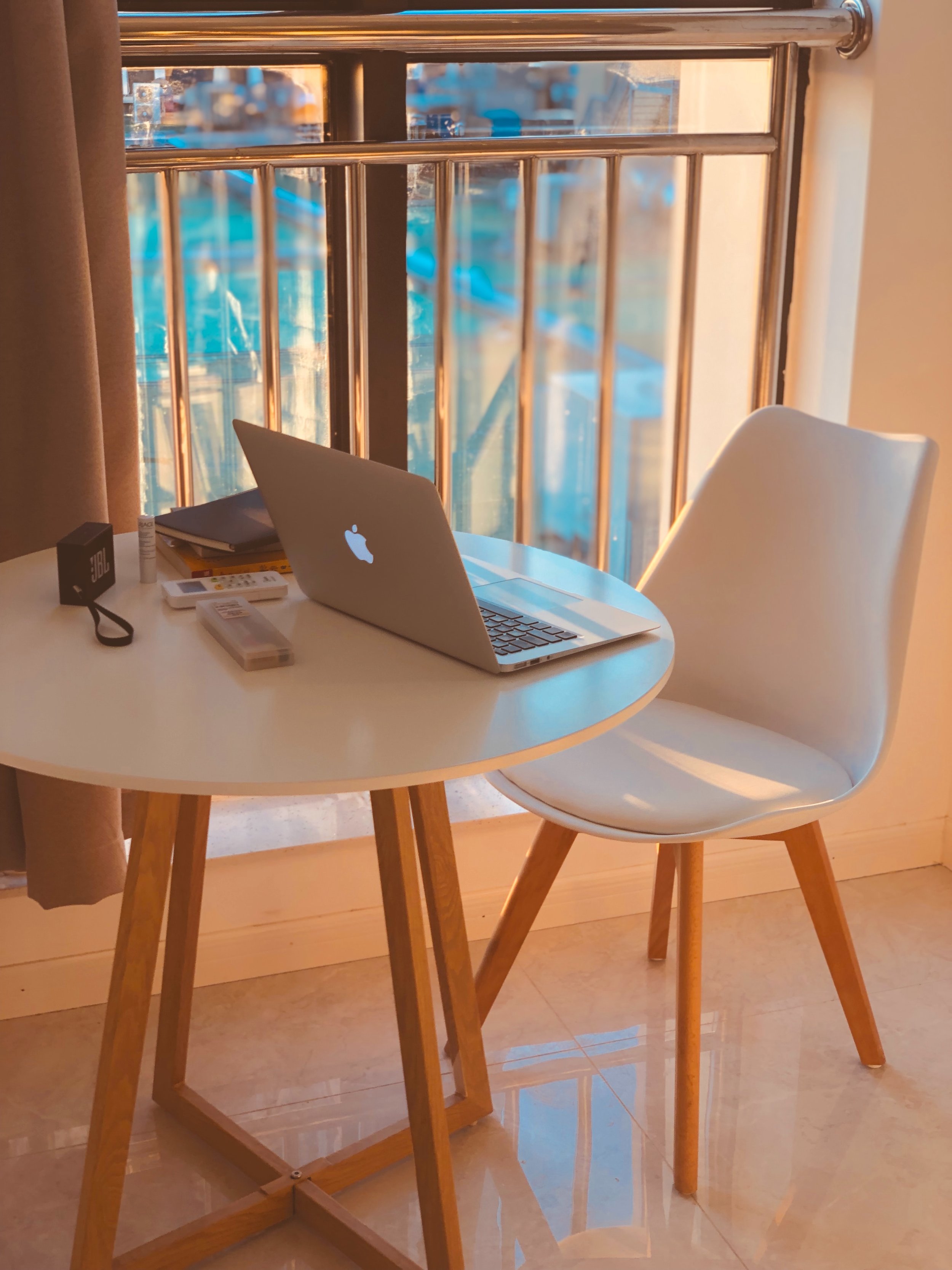 a modern ikea like table with a white chair with an apple laptop sitting on the table, online therapy, counseling for women
