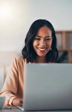 black woman in her home smiling during online therapy, online therapy what to expect and how to choose the right therapist