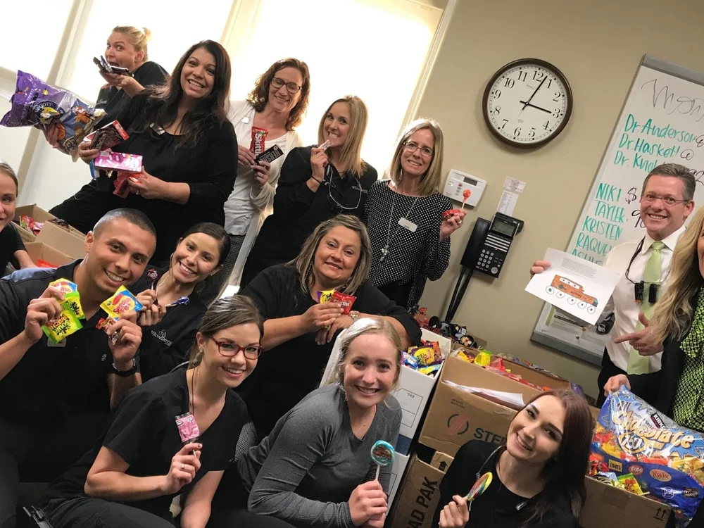 A dental office team with their Halloween candy collection