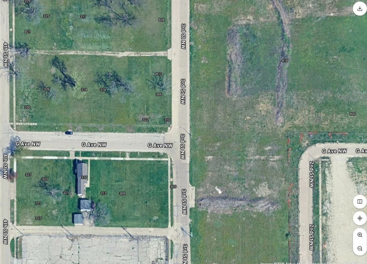 Aerial view of a neighborhood with streets, lawns, trees, and houses.