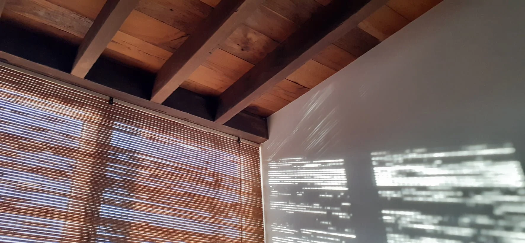 Reclaimed natural timber ceiling detail with bamboo blind and filtered light - Brighton loft extension - Feron Architects
