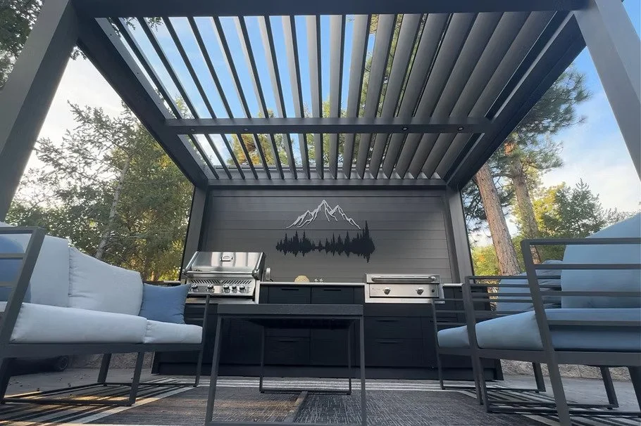 View looking up through slats within pergola showing chairs and outdoor kitchen