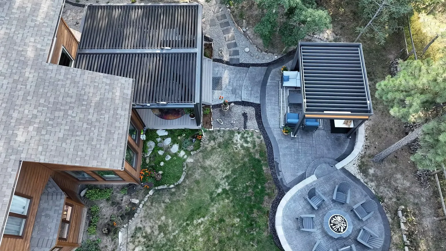 Drone image of outdoor patio that features a pergola, back patio, and fire pit