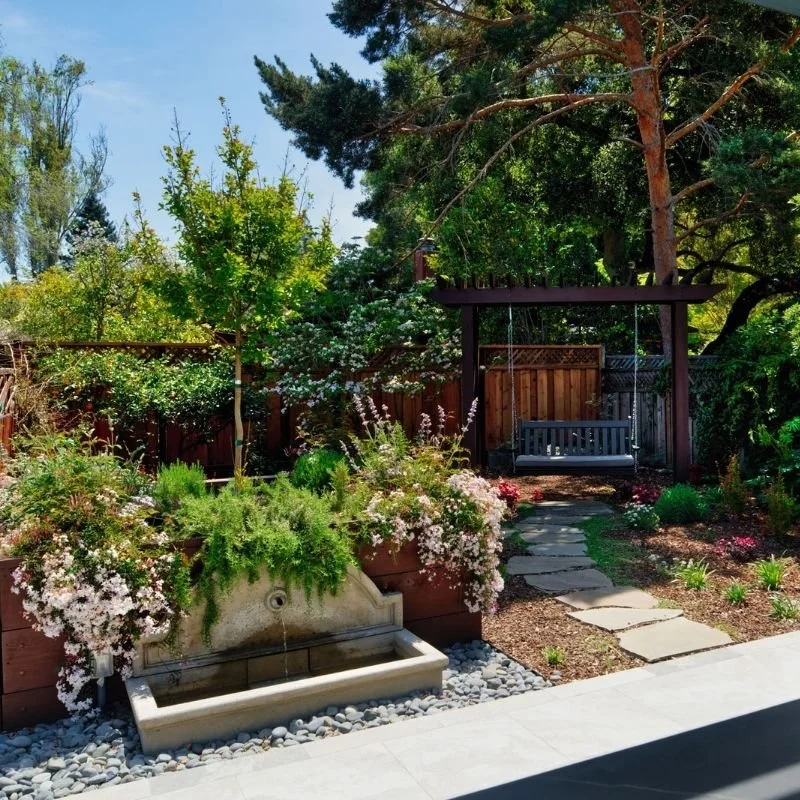 a beautiful backyard with a fountain and swing