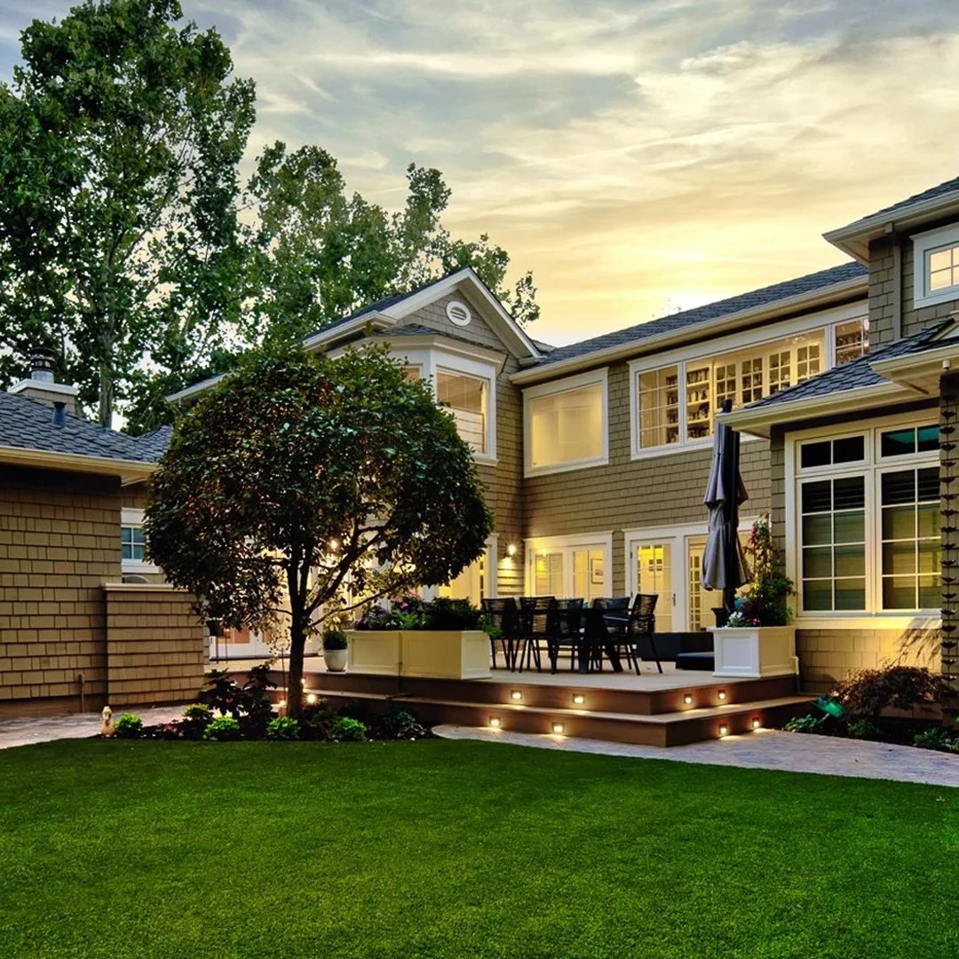 lit up house with a beautiful yard