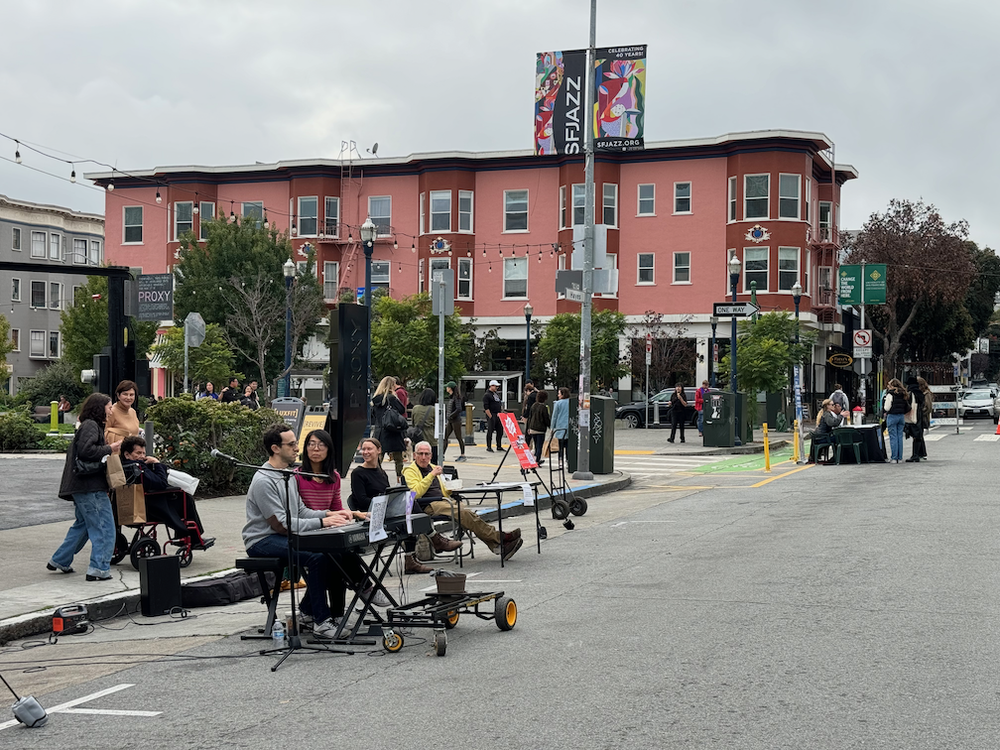 Three-Handed Jazz performs on car-free Hayes. In the background, Hayes Valley for All and SFMTA both set up community engagement tables.
