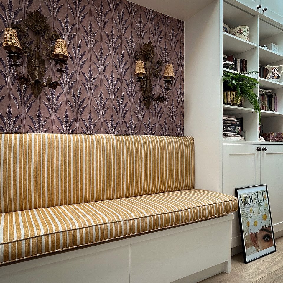 Looking back on this reading nook design with a fitted storage bench, upholstered in the very versatile York stripe @fermoie and custom-made wall sconces, crowned with rattan shades from @pookylights. The purple wallpaper is from @printsisters_archiv