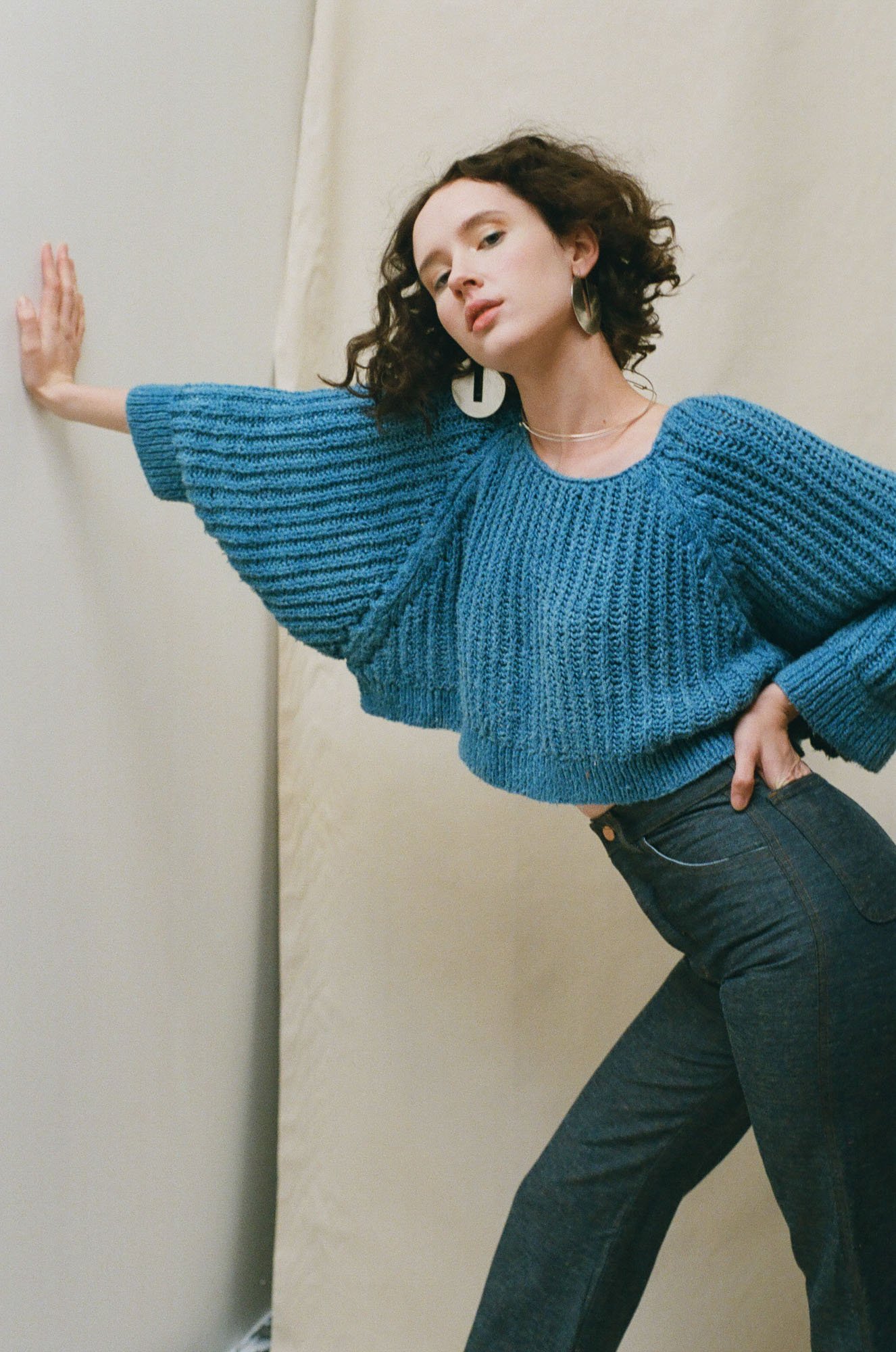  Expert Wardrobe Consultancy by Charlotte Sims —&nbsp;A woman in a blue sweater leaning against a wall. 