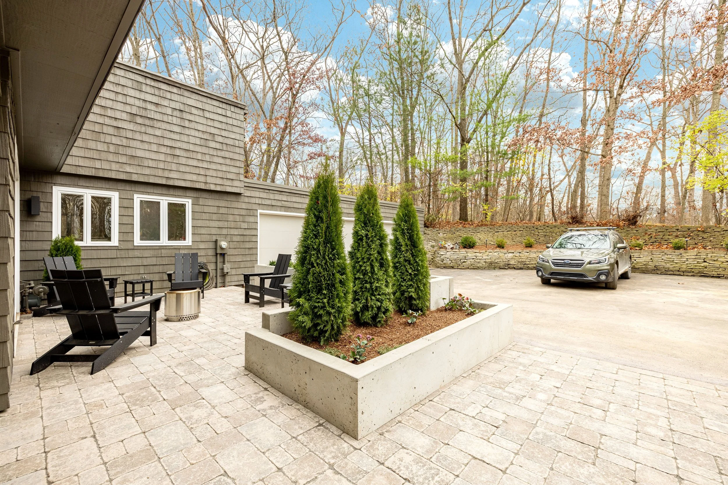 Three trees in a planter in the middle of a custom patio