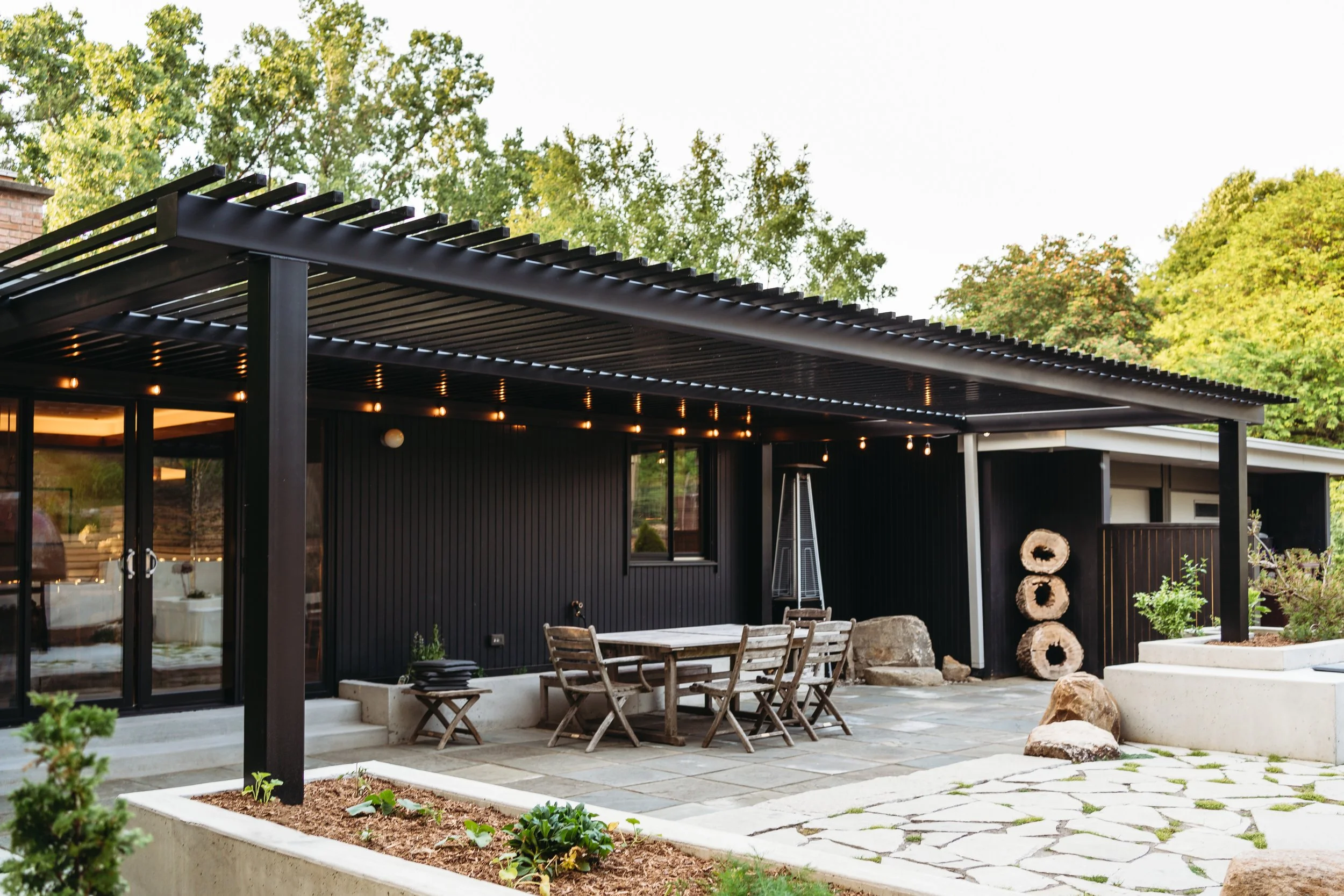 Pergola over custom patio with lighting and planters