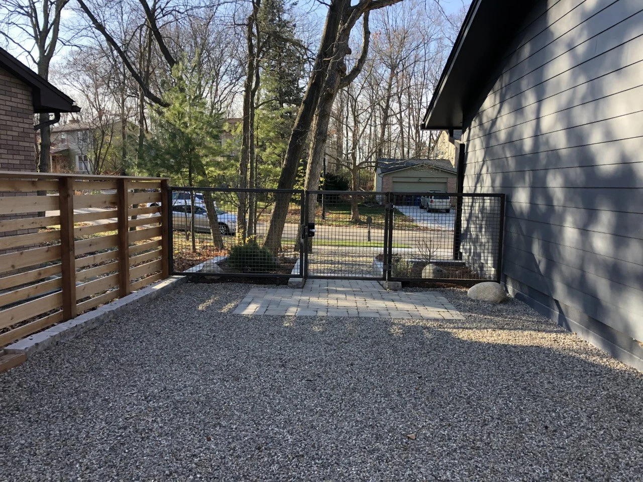 Gravel yard with wood and metal fencing
