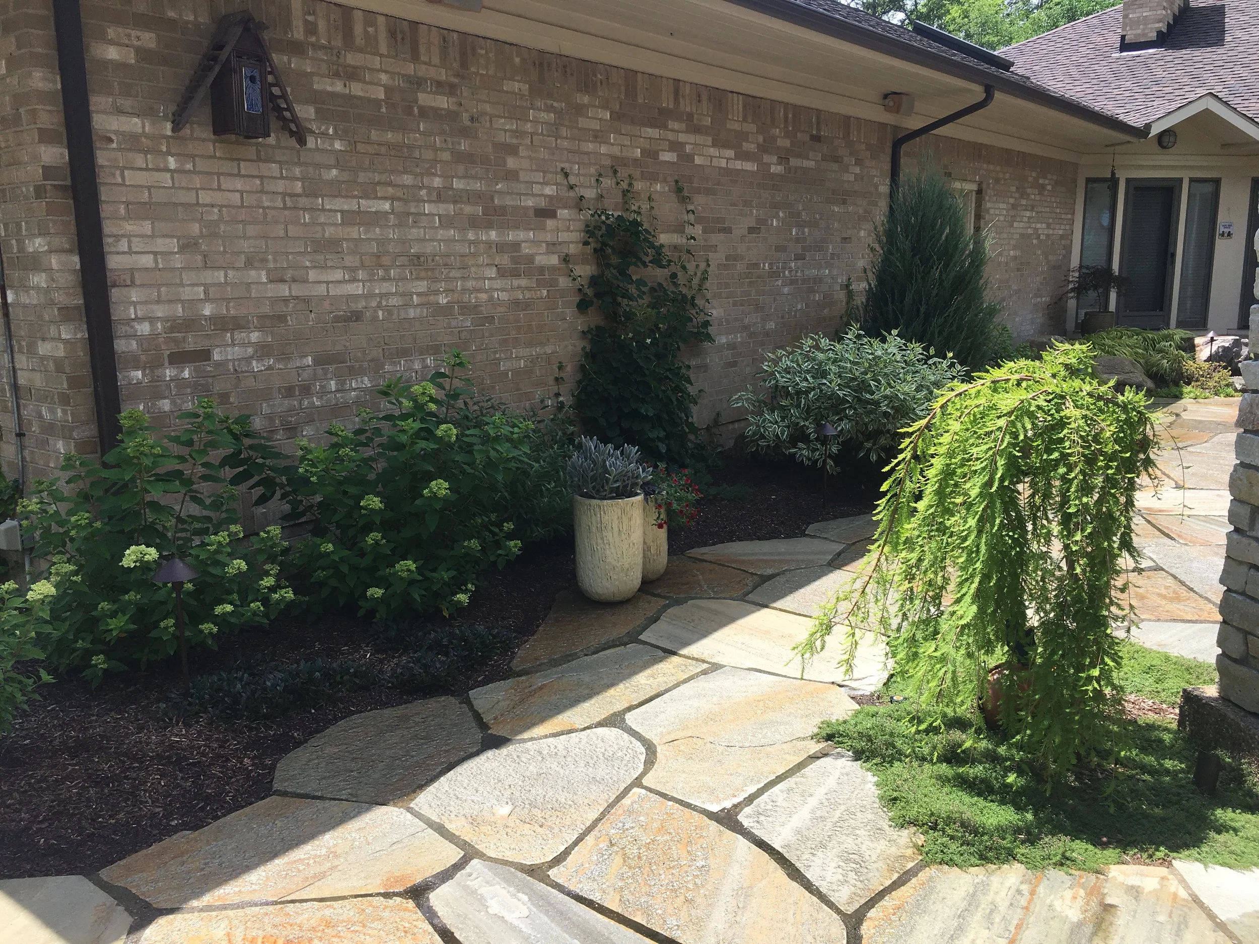 Stone walkway flanked by bushes